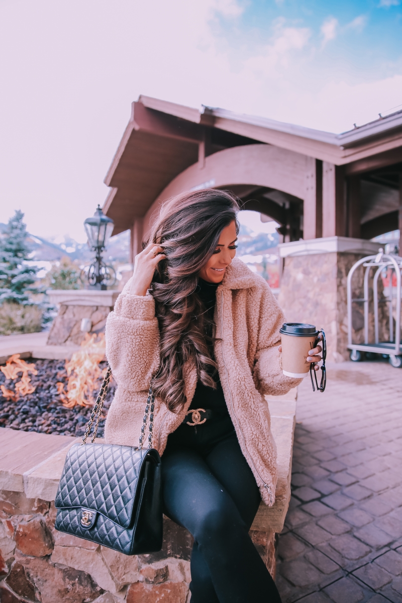 Fall fashion pinterest 2018, teddy bear coat outfit pinterest 2018, IAMGIA teddy coat, chanel belt outfit, park city travel fashion blogger, emily gemma blog, chanel classic black maxi-3 | I Am Gia Teddy Bear Jacket by popular US fashion blog, The Sweetest Thing: image of a woman standing outside next to a gas fire pit and wearing a Pixie Coat  I.AM.GIA brand: I.AM.GIA, H&M Ribbed Turtleneck Top, Nordstrom Florence Instasculpt Ankle Skinny Jeans DL1961, ShopBop Ash boots, H&M Large Earrings, Nordstrom Lip Cheat Lip Liner CHARLOTTE TILBURY, Chanel belt, Chanel purse, and Nordstrom MAC Matte Lipstick MAC COSMETICS.