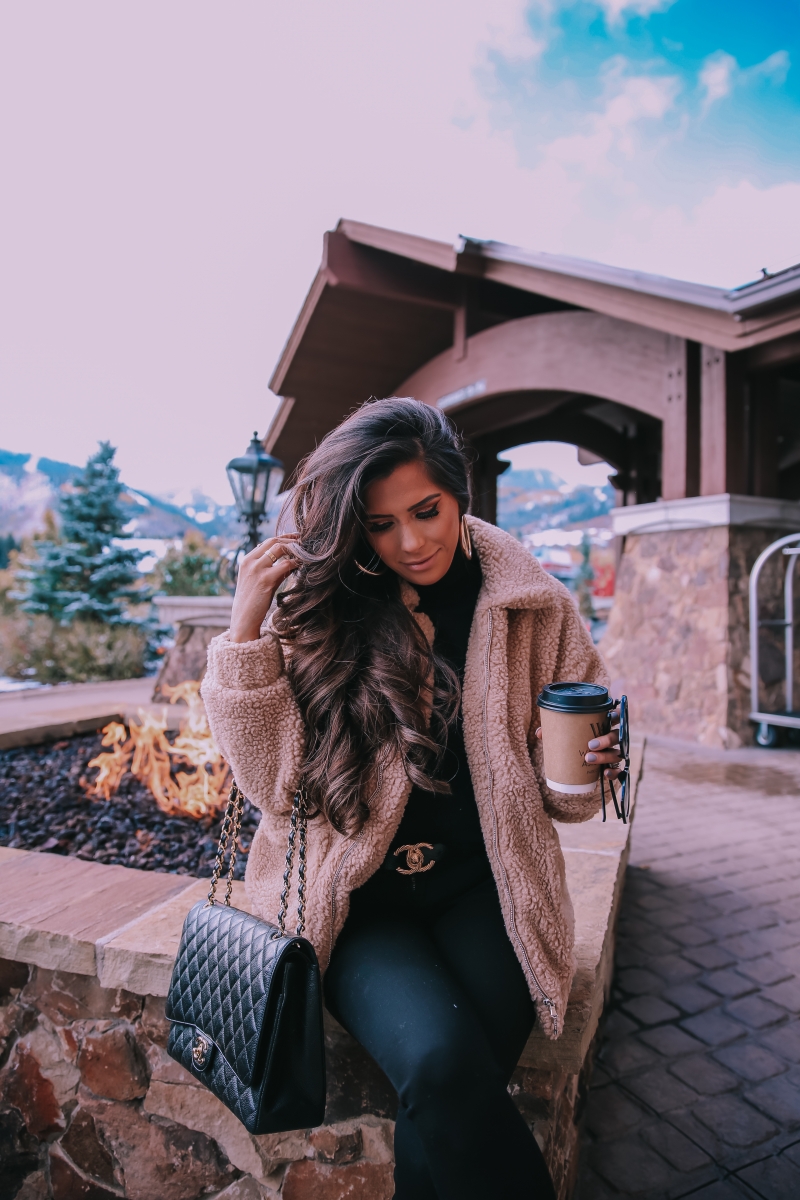 Fall fashion pinterest 2018, teddy bear coat outfit pinterest 2018, IAMGIA teddy coat, chanel belt outfit, park city travel fashion blogger, emily gemma blog, chanel classic black maxi-3 | I Am Gia Teddy Bear Jacket by popular US fashion blog, The Sweetest Thing: image of a woman standing outside next to a gas fire pit and wearing a Pixie Coat  I.AM.GIA brand: I.AM.GIA, H&M Ribbed Turtleneck Top, Nordstrom Florence Instasculpt Ankle Skinny Jeans DL1961, ShopBop Ash boots, H&M Large Earrings, Nordstrom Lip Cheat Lip Liner CHARLOTTE TILBURY, Chanel belt, Chanel purse, and Nordstrom MAC Matte Lipstick MAC COSMETICS.