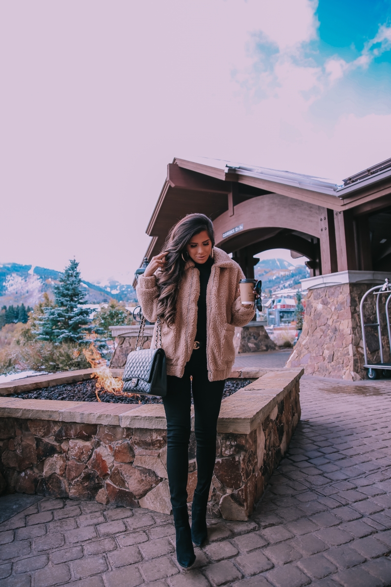 Fall fashion pinterest 2018, teddy bear coat outfit pinterest 2018, IAMGIA teddy coat, chanel belt outfit, park city travel fashion blogger, emily gemma blog, chanel classic black maxi-3 | I Am Gia Teddy Bear Jacket by popular US fashion blog, The Sweetest Thing: image of a woman standing outside next to a gas fire pit and wearing a Pixie Coat  I.AM.GIA brand: I.AM.GIA, H&M Ribbed Turtleneck Top, Nordstrom Florence Instasculpt Ankle Skinny Jeans DL1961, ShopBop Ash boots, H&M Large Earrings, Nordstrom Lip Cheat Lip Liner CHARLOTTE TILBURY, Chanel belt, Chanel purse, and Nordstrom MAC Matte Lipstick MAC COSMETICS.