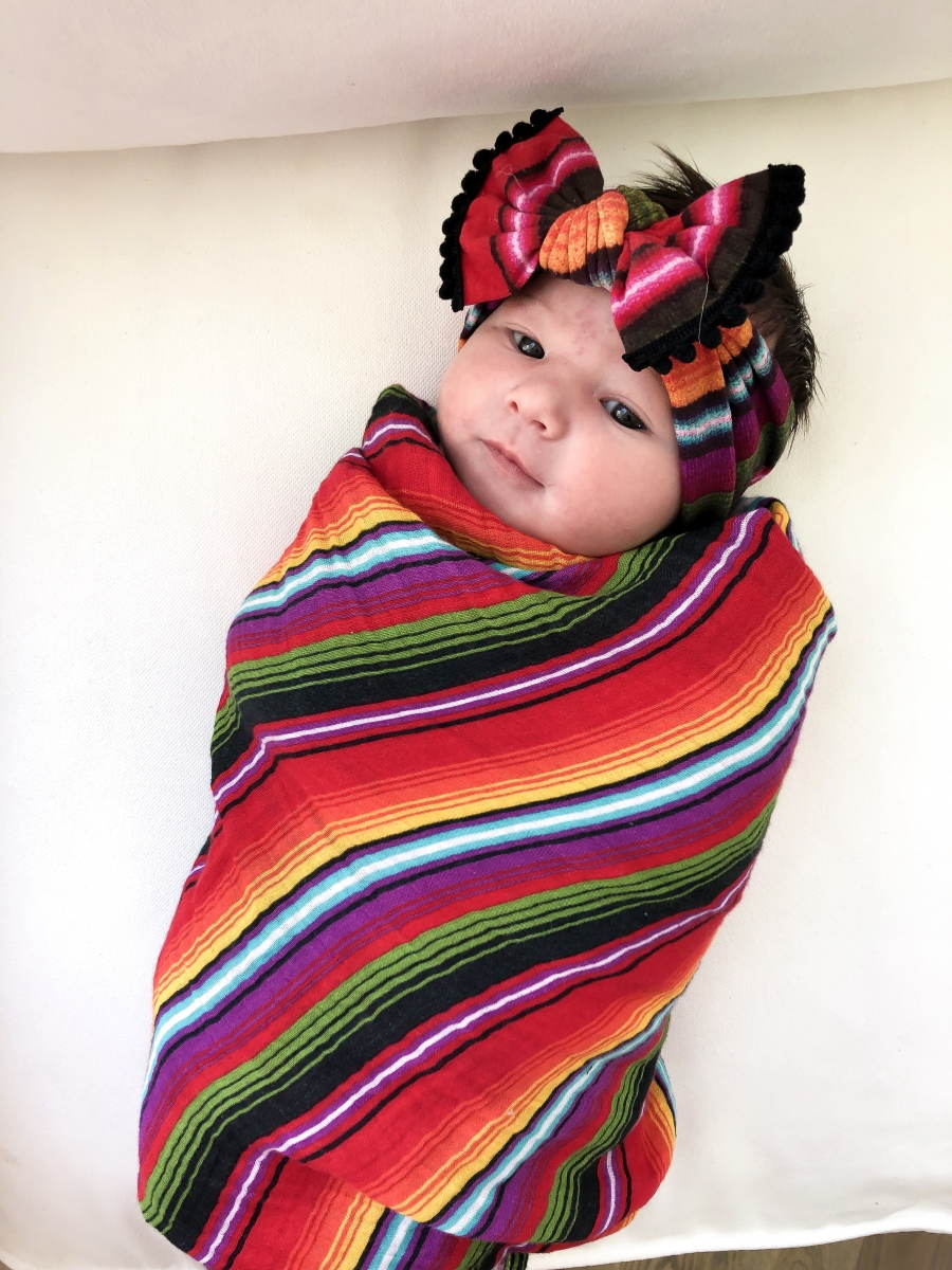 Emily Ann Gemma of The Sweetest Thing Blog with new baby. Colorful baby blanket and bow.