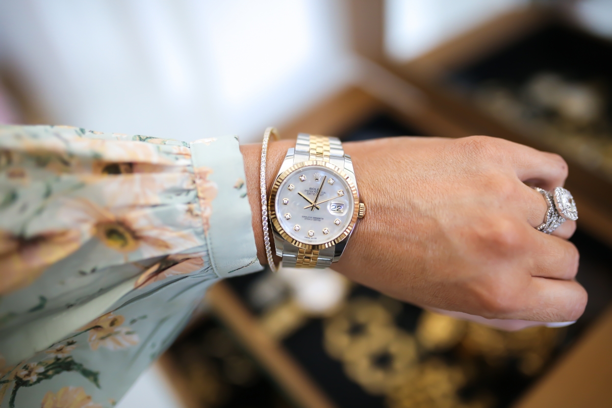 Emily Ann Gemma of The Sweetest Thing blog on purchasing luxury watches, like Rolex, from eBay. Floral dress, headband, and gold jewelry.