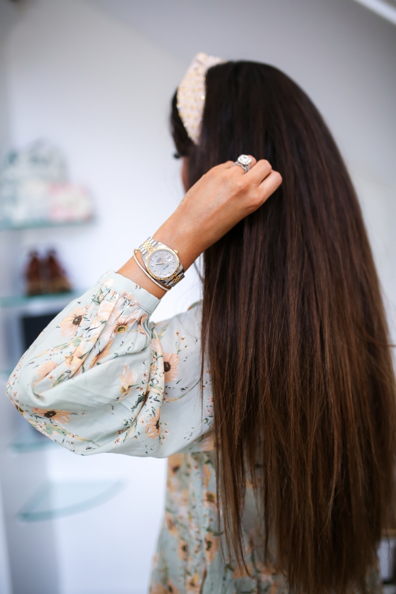 Emily Ann Gemma of The Sweetest Thing blog on purchasing luxury watches, like Rolex, from eBay. Floral dress, headband, and gold jewelry.