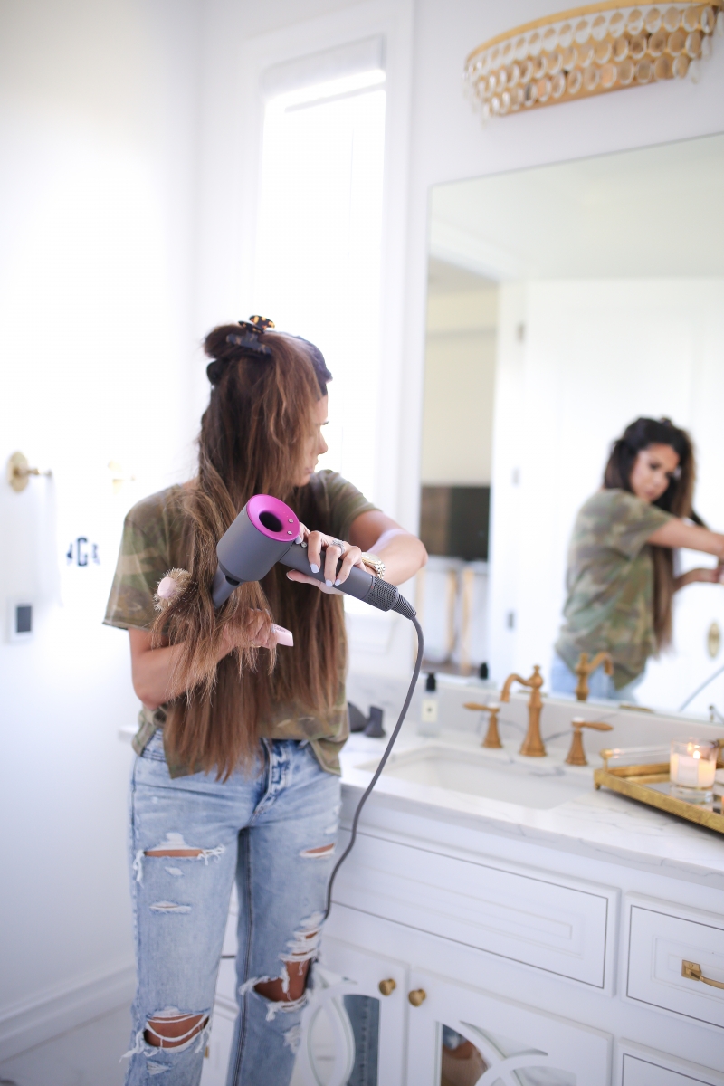 Emily Ann Gemma of The Sweetest Thing Blog review of the Dyson Hair Dryer. | Dyson Hair Dryer by popular US beauty blog, The Sweetest Thing: image of a woman using a Dyson hair dryer.