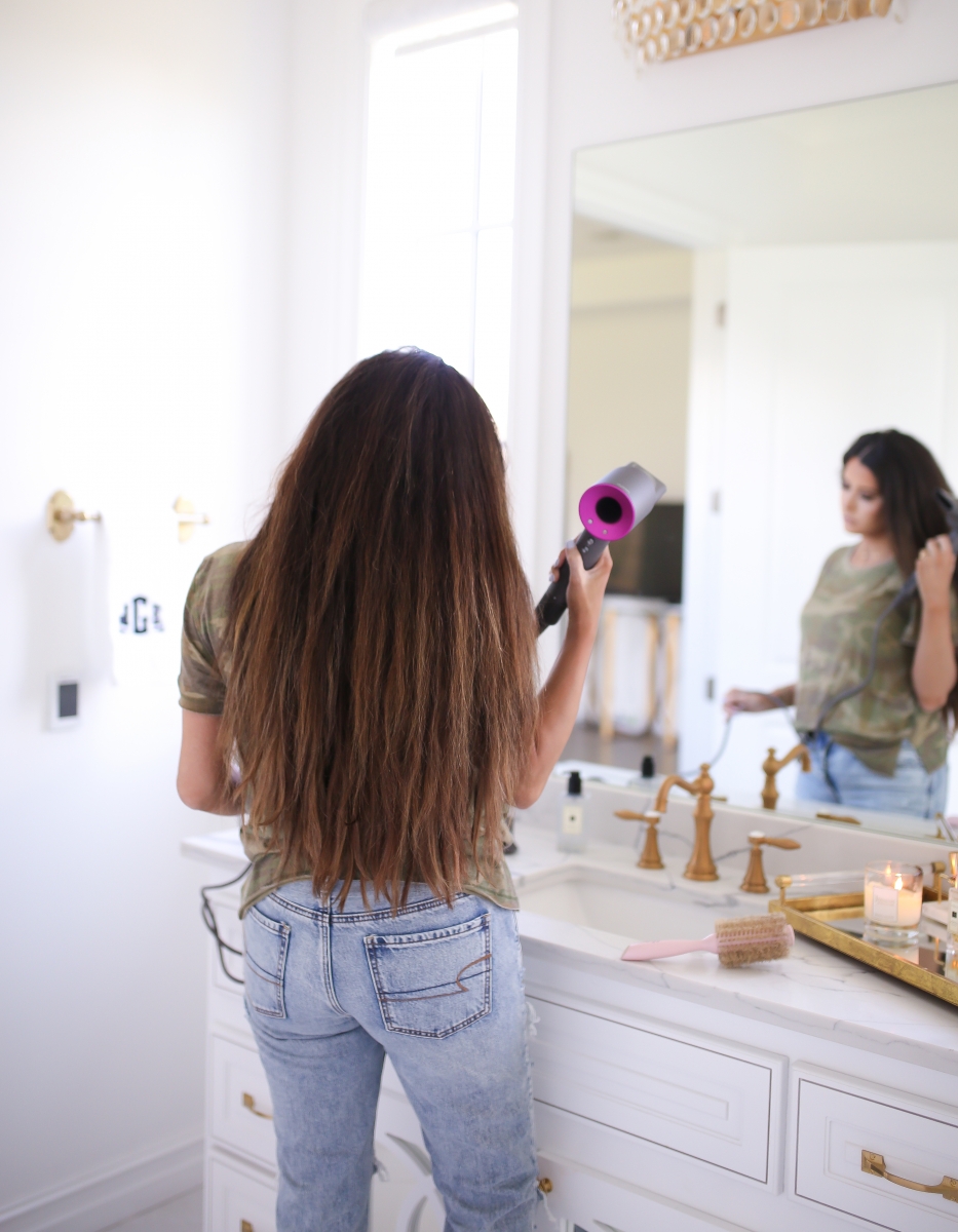 Emily Ann Gemma of The Sweetest Thing Blog review of the Dyson Hair Dryer. | Dyson Hair Dryer by popular US beauty blog, The Sweetest Thing: image of a woman holding a Dyson hair dryer.