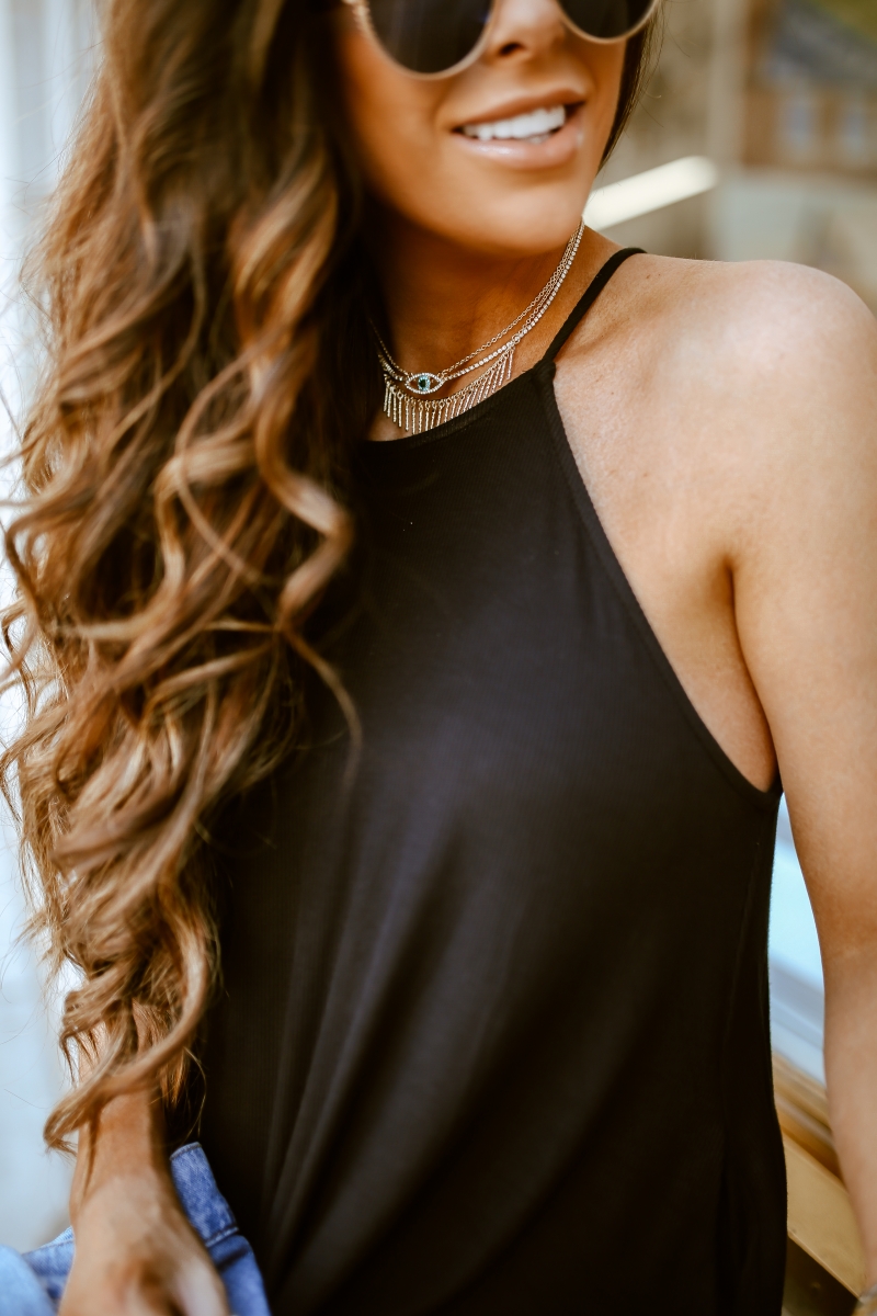 Emily Ann Gemma of The Sweetest Thing Blog in an under $40 black dress, pearl embellished denim jacket, white Chanel handbag, and platform tennis shoes from Steve Madden.