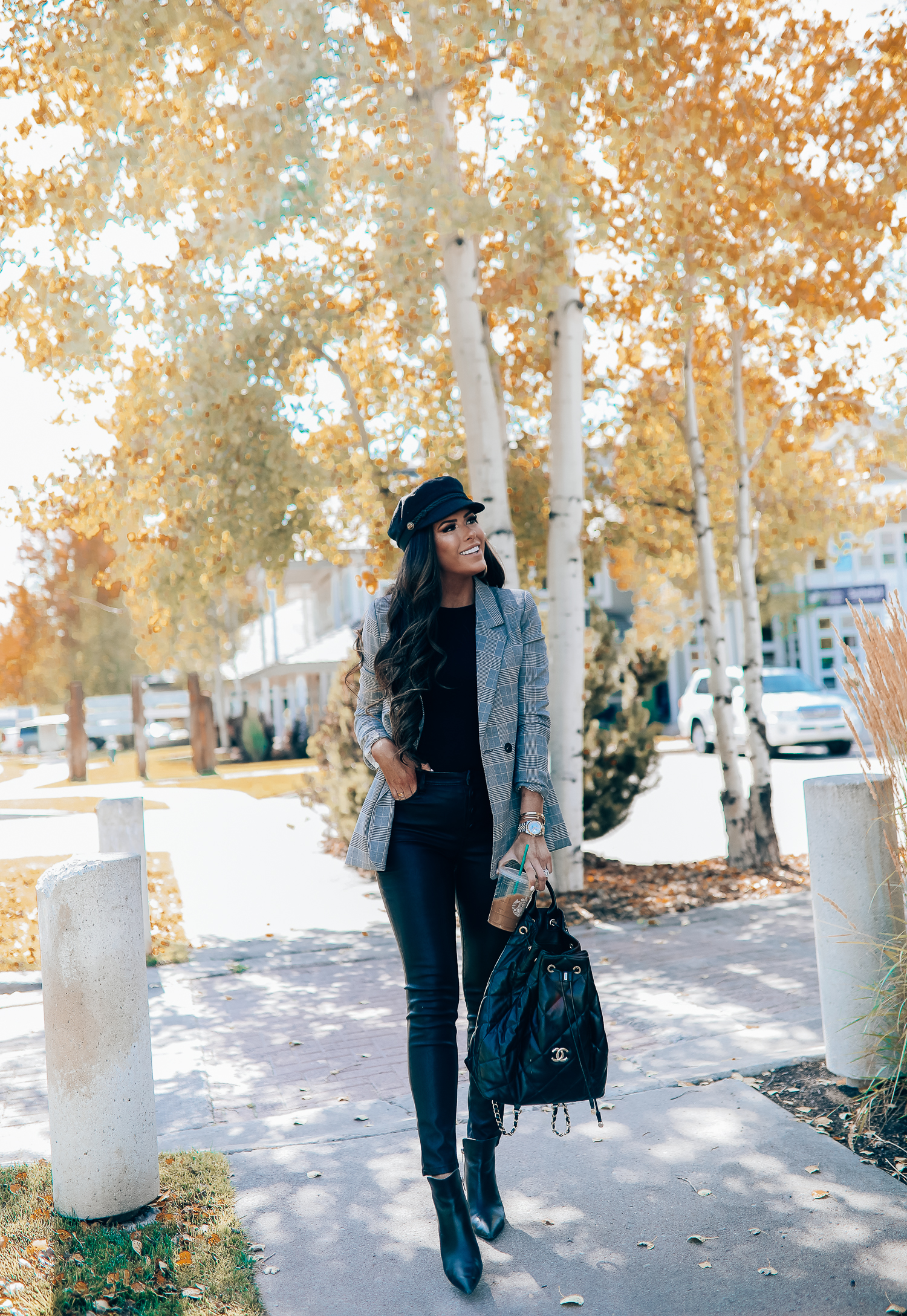 Oversized plaid blazer styled for Fall by top US fashion blog, The Sweetest Thing: image of a woman wearing an Aqua oversized plaid blazer, Splendid long sleeve top, BlankNYC vegan leggings, Marc Fisher booties, Chanel backpack, Baker boy cap, a Rolex watch, Argento Vivo earrings, and Cartier bracelets