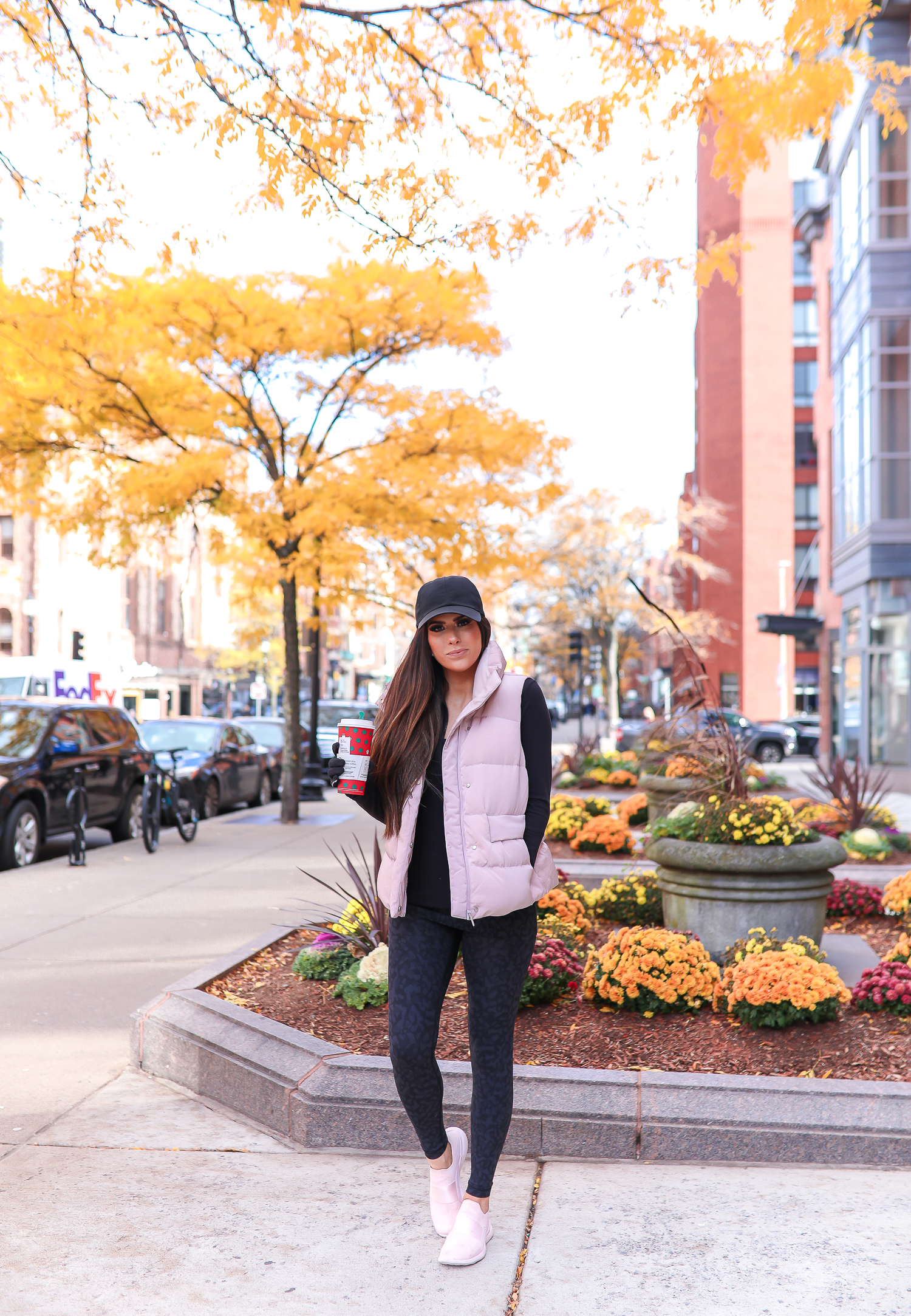 Lululemon Leopard Leggings and Vest Outfit featured by top US fashion blog, The Sweetest Thing: image of a woman wearing Lululemon Leopard Leggings, Lululemon oversized puffer vest, Lululemon black jacket and a Lululemon sports bra.