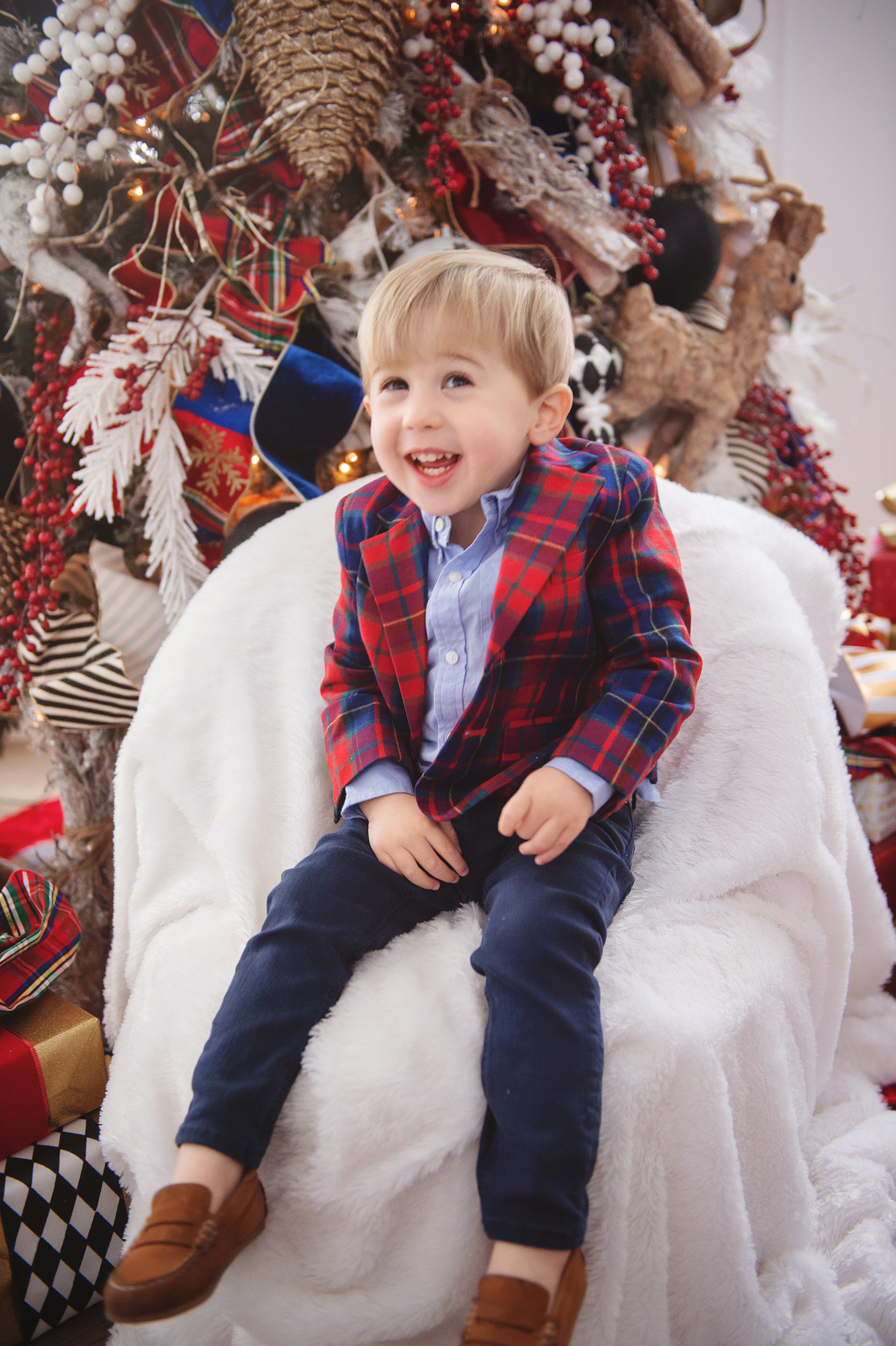 family Christmas card outfit inspiration, smocked Christmas dress baby, baby boy fashion Christmas, pinterest Christmas tree decor, shop hello holidays, Emily Gemma, the sweetest thing blog | Merry Christmas Wishes To You & Yours🎁❤️🎄 [Our Christmas Card 2019] by popular Oklahoma life and style blog, The Sweetest Thing: image of a little boy sitting in front of their Christmas tree and wearing Zara BASIC SERGED SKINNY JEANS, Zara  LEATHER LOAFERS, Janie and Jack POPLIN SHIRT, Janie and Jack PLAID WOOL BLAZER.
