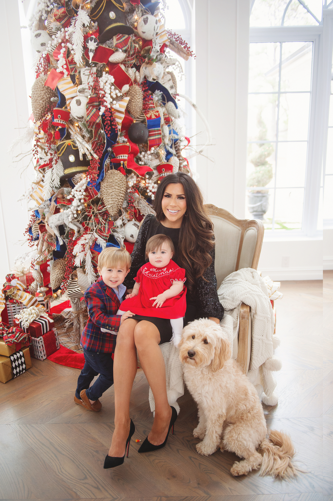 family Christmas card outfit inspiration, smocked Christmas dress baby, baby boy fashion Christmas, pinterest Christmas tree decor, shop hello holidays, Emily Gemma, the sweetest thing blog | Merry Christmas Wishes To You & Yours🎁❤️🎄 [Our Christmas Card 2019] by popular Oklahoma life and style blog, The Sweetest Thing: image a family standing in front of their Christmas tree and wearing Smocked Auctions MERRY CHRISTMAS SMOCKED BISHOP RED CORDUROY dress, Zara BASIC SERGED SKINNY JEANS, Zara  LEATHER LOAFERS, Janie and Jack POPLIN SHIRT, Janie and Jack PLAID WOOL BLAZER, CHRISTIAN LOUBOUTIN So Kate 120 suede pumps, and Nordstrom Eliza J Long Sequin Sleeve Sheath Dress.