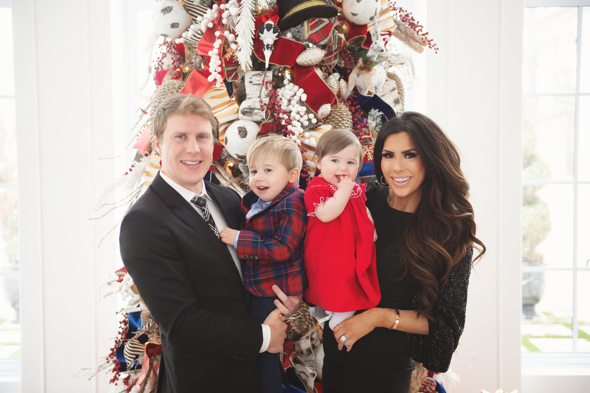 family Christmas card outfit inspiration, smocked Christmas dress baby, baby boy fashion Christmas, pinterest Christmas tree decor, shop hello holidays, Emily Gemma, the sweetest thing blog | Merry Christmas Wishes To You & Yours🎁❤️🎄 [Our Christmas Card 2019] by popular Oklahoma life and style blog, The Sweetest Thing: image a family standing in front of their Christmas tree and wearing Smocked Auctions MERRY CHRISTMAS SMOCKED BISHOP RED CORDUROY dress, Zara BASIC SERGED SKINNY JEANS, Zara  LEATHER LOAFERS, Janie and Jack POPLIN SHIRT, Janie and Jack PLAID WOOL BLAZER, Nordstrom Burberry men's tie, Nordstrom Boss Huge/Genius Trim Fit Solid Wool Suit, CHRISTIAN LOUBOUTIN So Kate 120 suede pumps, and Nordstrom Eliza J Long Sequin Sleeve Sheath Dress.