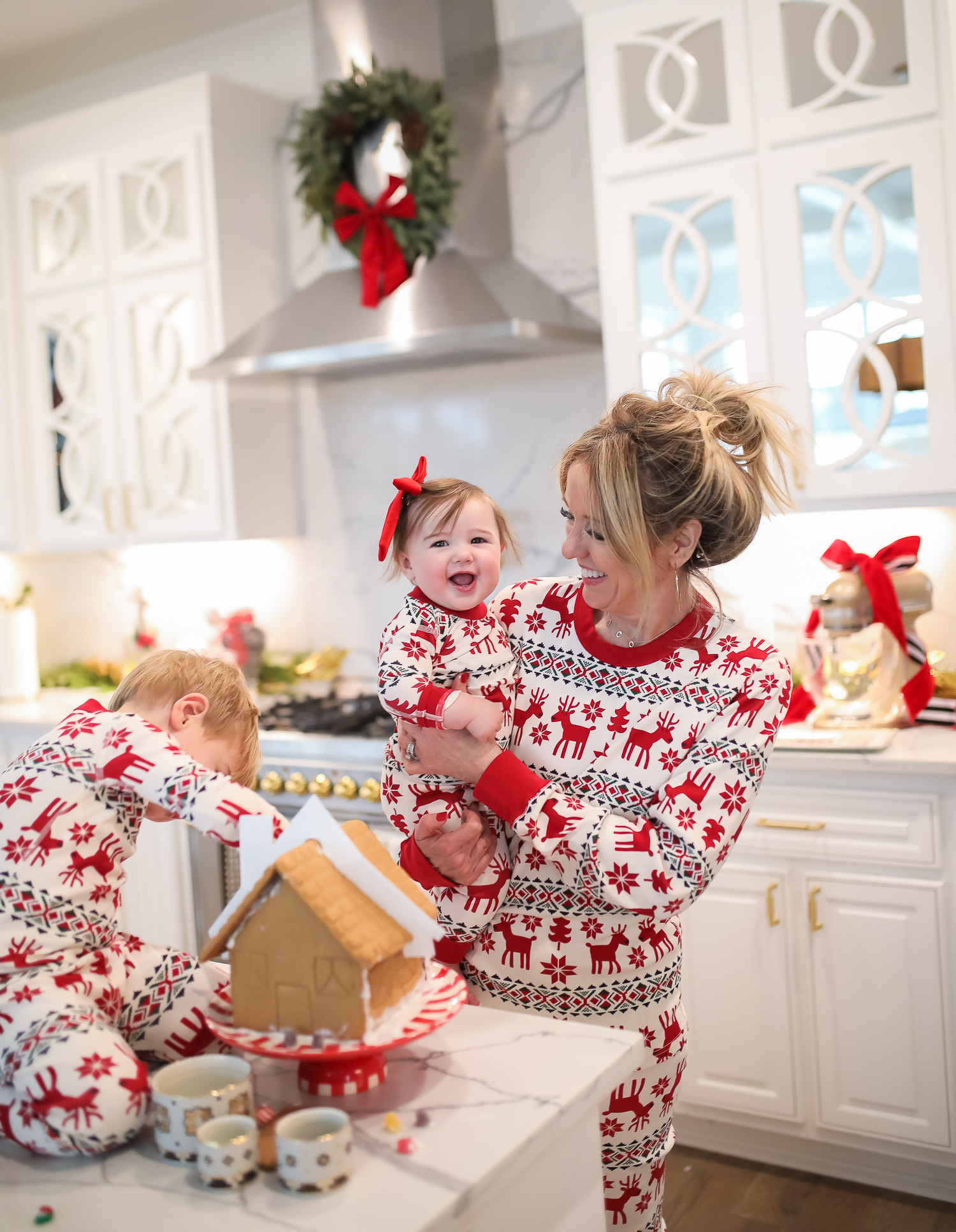 Hanna Anderson pjs christmas, family matching christmas pajamas, christmas decor pajamas 2019 pinterest, babies christmas pajamas matching, the sweetest thing blog-5 | Coco & Crew In Matching Hanna Andersson Christmas Pajamas by popular Oklahoma life and style blog, The Sweetest Thing: image of a family decorating gingerbread houses and wearing Hanna Andersson Long John Pajamas In Organic Cotton, Hanna Andersson Adult Long John Pant In Organic Cotton, Hanna Andersson Women's Long John Top In Organic Cotton, Hanna Andersson Adult Long John Top In Organic Cotton, and Hanna Andersson Adult Long John Pant In Organic Cotton.