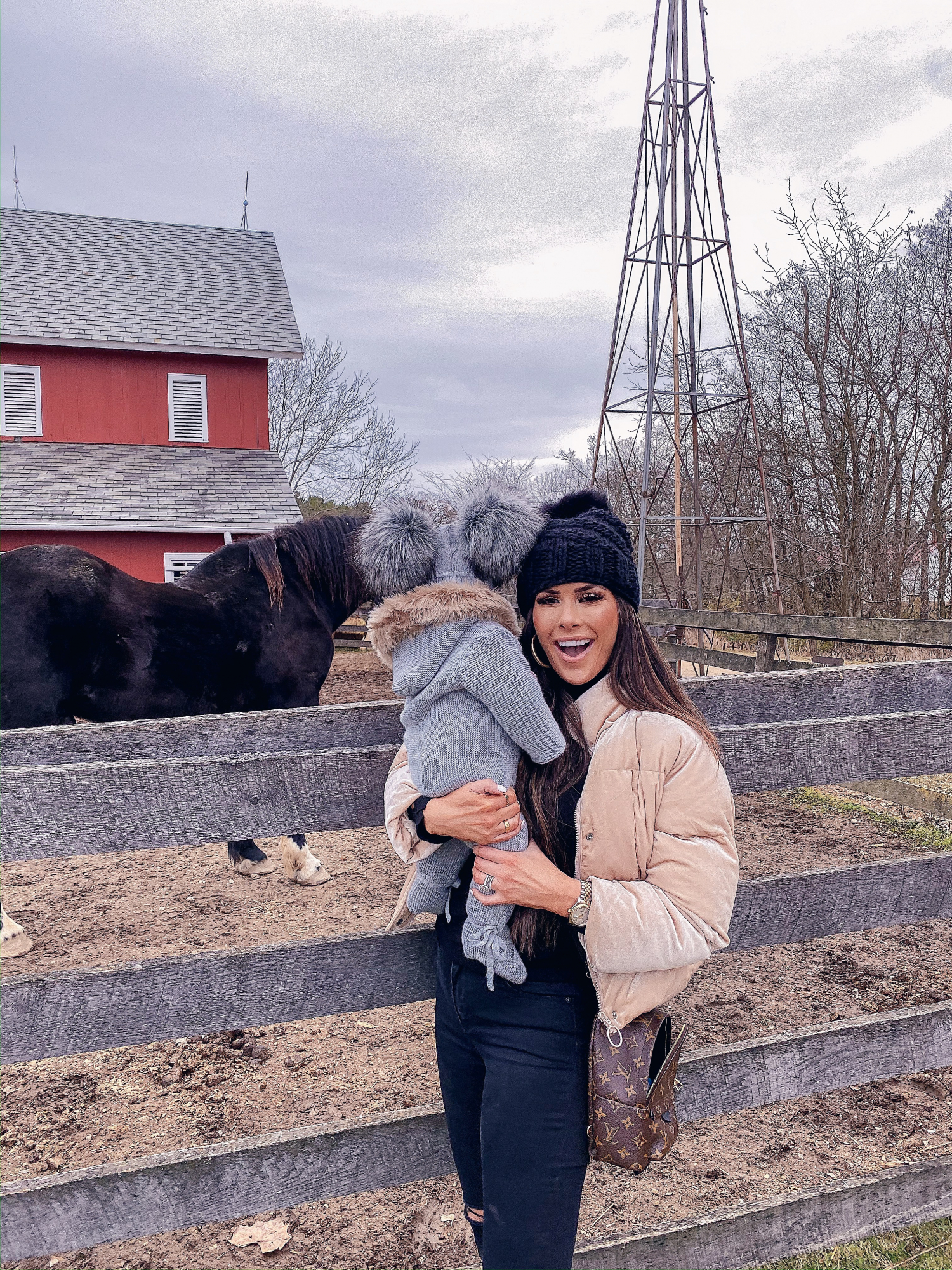 baby girl fashionista, double pom pom beanie | A YEAR IN REVIEW : MASSIVE 2019 INSTAGRAM RECAP by popular Oklahoma life and style blog, The Sweetest Thing: image of a mom holding her baby next to a black horse and wearing a Nordstrom Joan of Arctic II Lux Wedge Genuine Shearling Bootie SOREL, Louis Vuitton mini backpack, Nordstrom Mile High Ripped Super Skinny Jeans LEVI'S®, and BUDDYLOVE NICKS PUFFY ZIPPER CLOSURE JACKET - PEARL.