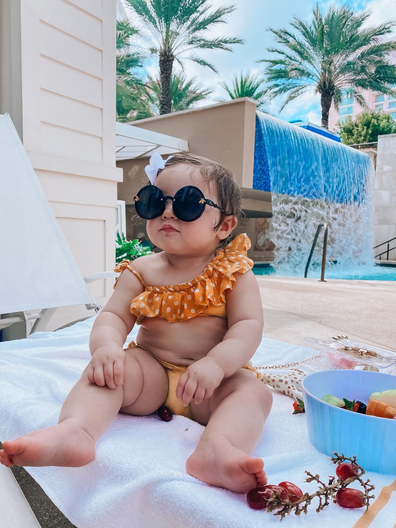 Instagram Fashion by popular US fashion blog, The Sweetest Thing: image of a baby wearing black round frame sunglasses, a Amazon Korobeauty hair bow, and a Etsy two piece baby polka dot swimsuit. 