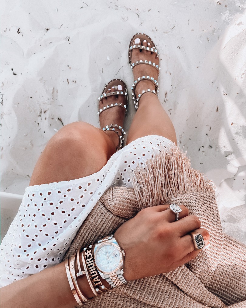 Instagram Fashion by popular US fashion blog, The Sweetest Thing: image of a woman wearing a Red Dress On That Note White Eyelet Dress, Intermix CULT GAIA Banu Twisted Raffia Clutcgh, Dior ring, Steve Madden Travel Tan sandals, and Dior and Cartier bracelets. 