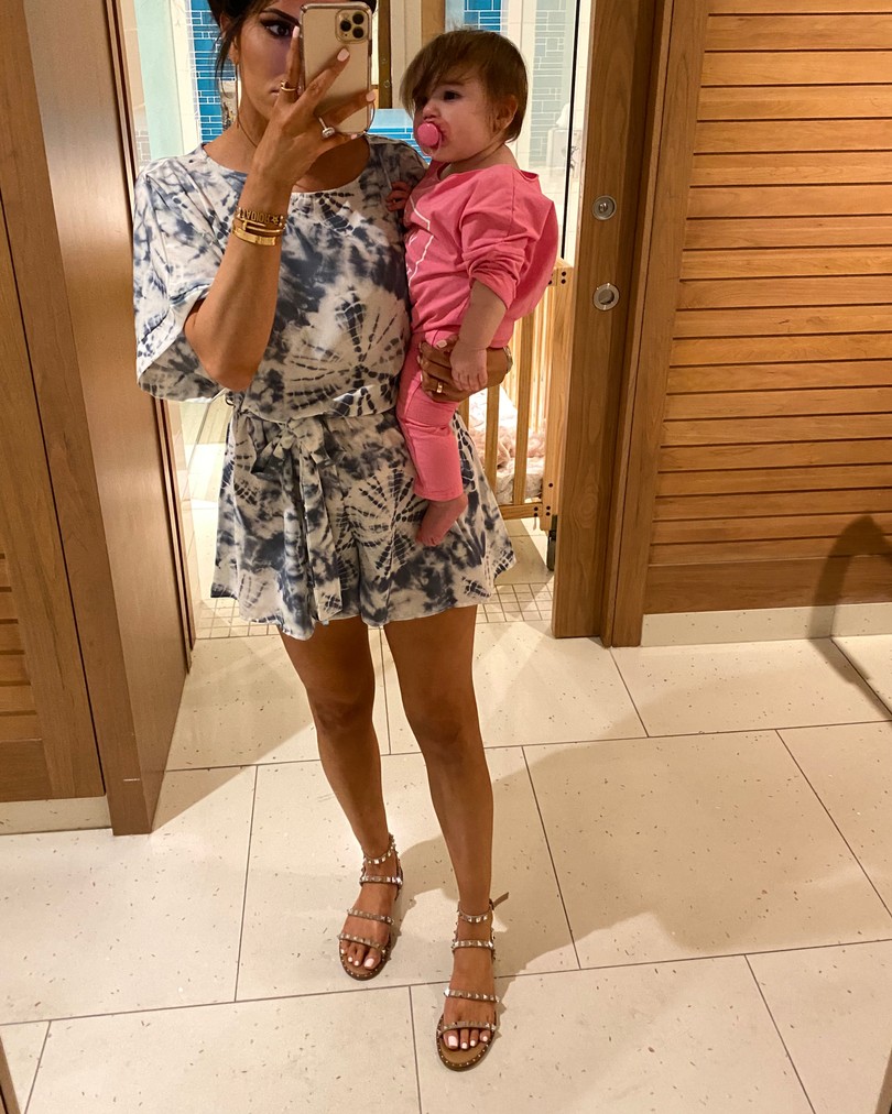 Instagram Fashion by popular US fashion blog, The Sweetest Thing: image of a woman holdign her baby and wearing a Red Dress Cool Touch Blue Tie Dye Print Romper and Steve Madden TRAVEL TAN sandals. 