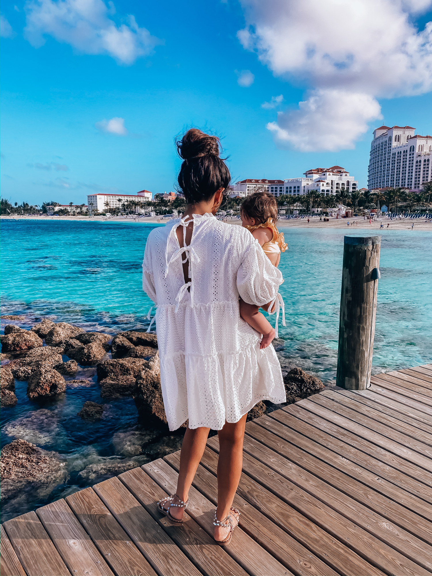 red dress boutique dresses, dior2society sunlasses, emily gemma | What to Wear in the Bahamas by popular US travel blog, The Sweetest Thing: image of a woman holding her baby girl and wearing a Red Dress On That Note White Eyelet Dress, CULT GAIA Banu Twisted Raffia Clutch, Dior DiorSociety2 Round Beaded Metal Sunglasses, Steve Madden TRAVEL CLEAR, Nordstrom Pillow Talk Lip Cheat Lip Liner CHARLOTTE TILBURY, Nordstrom Hot Lips Lipstick CHARLOTTE TILBURY, Nordstrom Gloss Luxe Moisturizing Lipgloss TOM FORD, Chanel Earrings, Dior and Cartier stack, Rolex watch, Dior Montaigne ring, Amazon Korobeauty Hair Bows, and a Etsy baby polka dot two piece. 