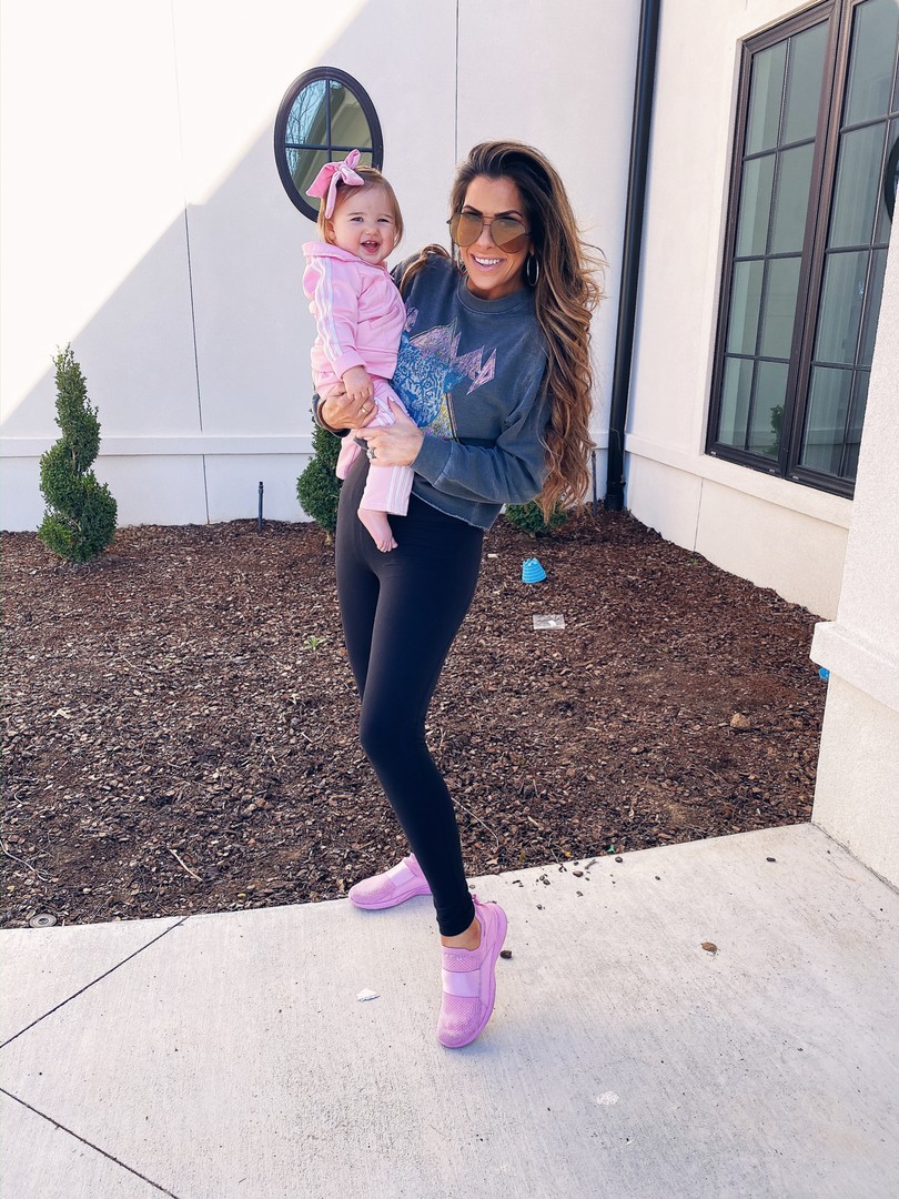 Instagram Recap by popular US lifestyle blog, The Sweetest Thing: image of Emily Gemma holding her daughter and wearing a Nordstrom Def Leppard Crop Sweatshirt VINYL ICONS, Nordstrom Live In High Waist Pocket 7/8 Leggings ZELLA, APL Women's TechLoom Bliss, Nordstrom High Key 65mm Oversize Rimless Aviator Sunglasses QUAY AUSTRALIA, Amazon adidas Baby Girls' Li'l Sport Tricot Pant & Jacket Active Clothing Set, and Amazon Ceelgon Big Hair Bow.