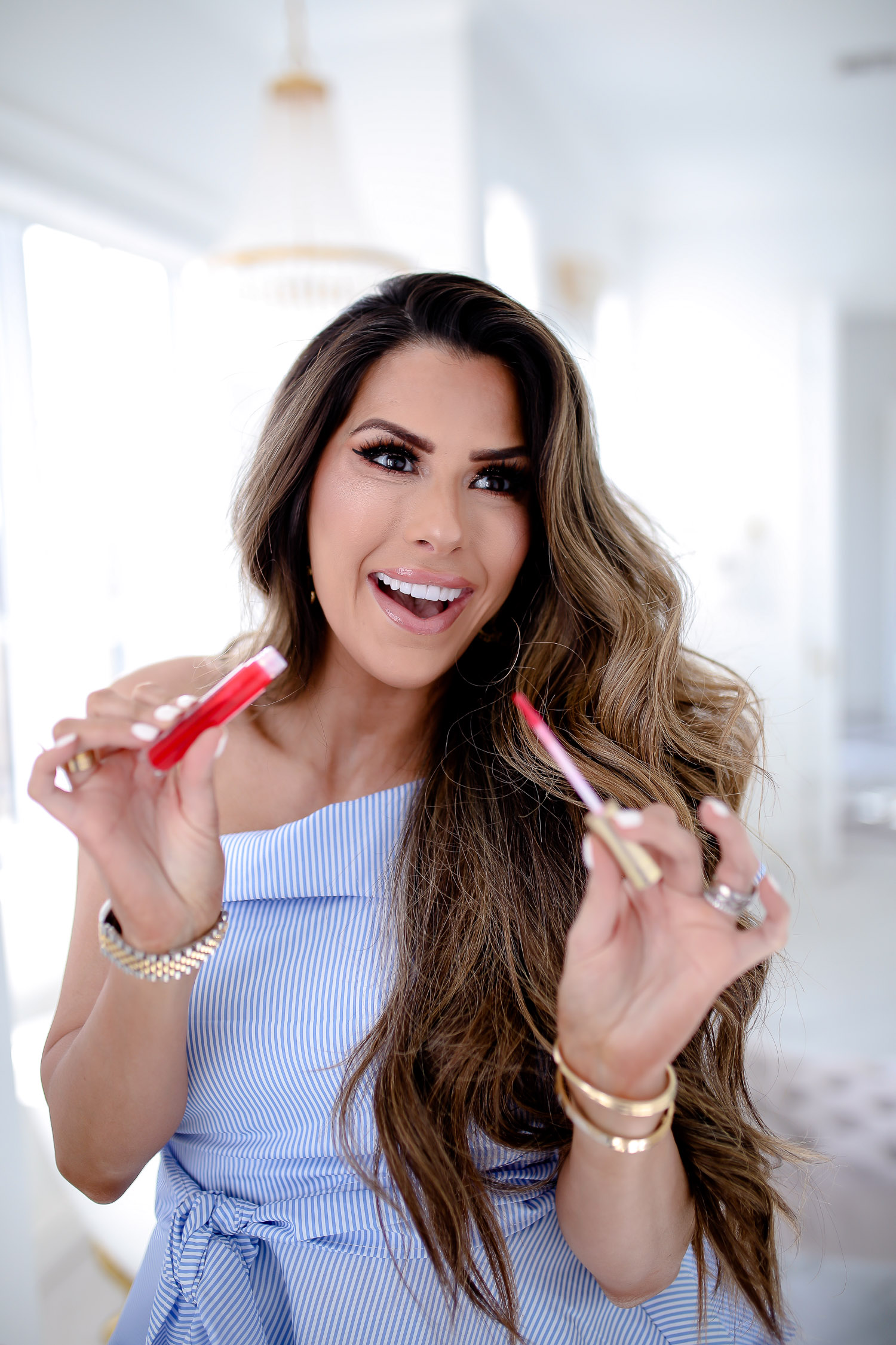 Too Faced Lip Injections Gloss by popular US beauty blog, The Sweetest Thing: image of a woman sitting in her bathroom and holding a Too Faced Lip Injections Gloss in her hands. 