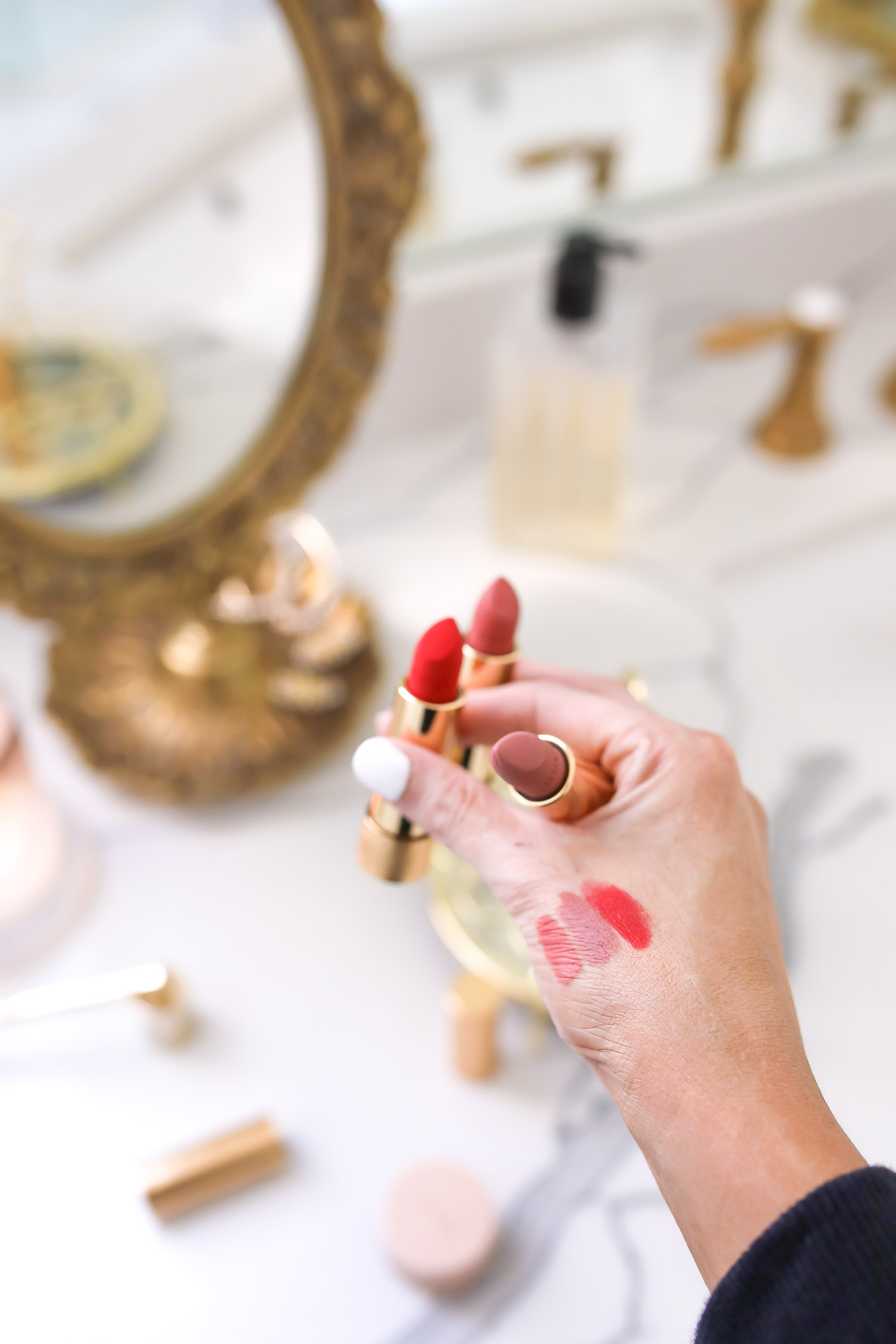 Gucci Lipsticks Review, Sephora Gucci Lipstick, Gucci Matte Lipstick Constance Vermillion, The Met In Argentina Gucci Lipstick, Painted Vail Gucci Lipstick, Emily Gemma | Rouge à Lèvres Matte Lipstick by popular US beauty blog, The Sweetest Thing: image of a woman holding 3 Rouge à Lèvres Matte Lipsticks in her hand. 