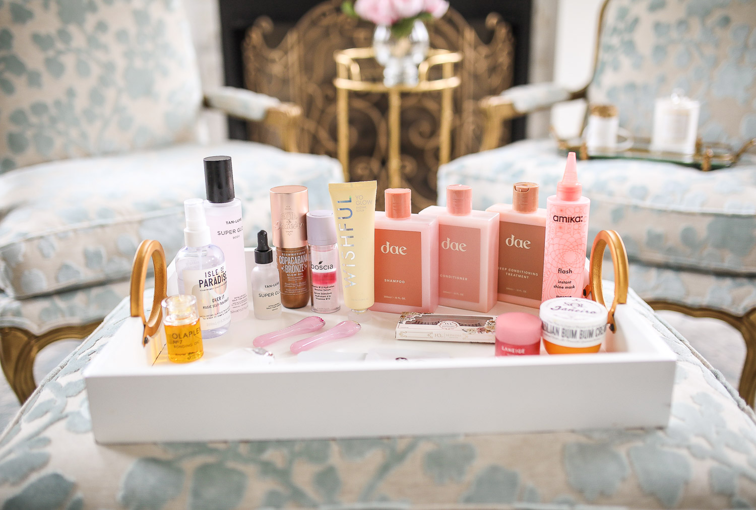 Sephora Haul spring 2020, best sephora products skincare spring 2020, DAE haircare review, Huda Beauty Wishful scrub review, sephora VIB event spring 2020 | Self Care Products by popular US life and style blog, The Sweetest Thing: image of a white enamel tray filled with Dae hair products, fake eye lashes, Amika flash instant shine mask, Wisheful Yo Glow, Tan Luxe Super Glow, and Olaplex.