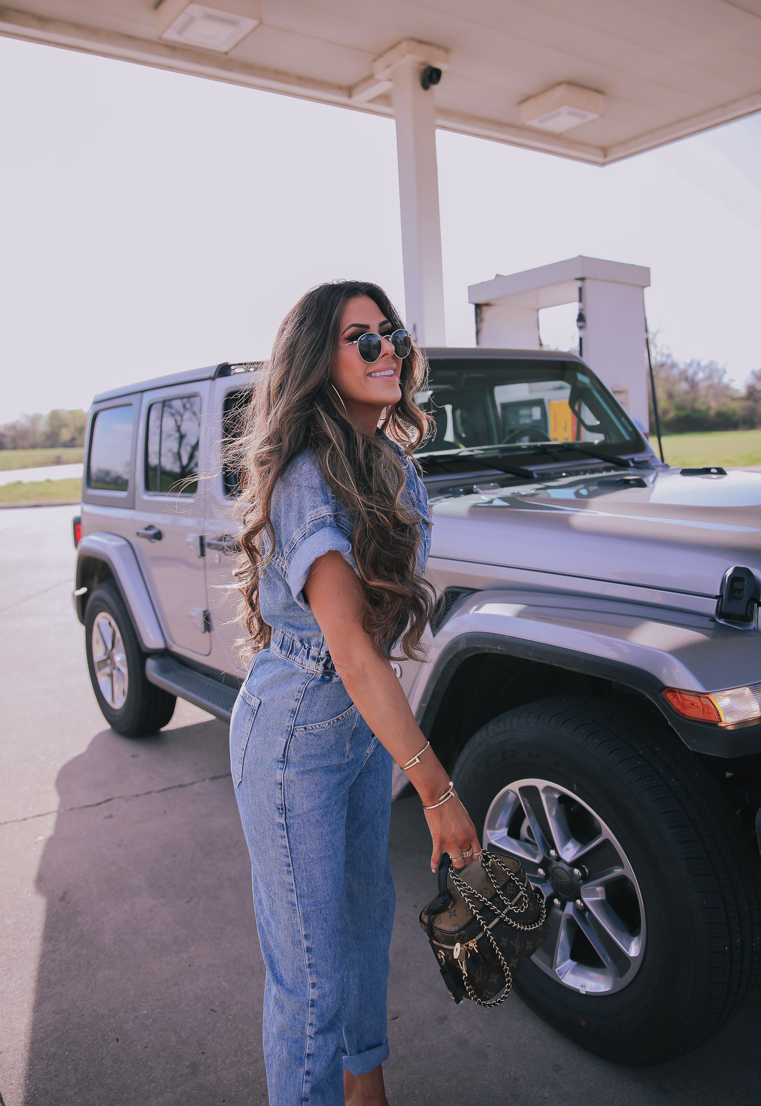 denim jumpsuit, free people denim jumpsuit coverall, emily ann gemma, spring fashion 2020, pinterest spring summer fashion 2020 | Denim Jumpsuit Outfit by popular US fashion blog, The Sweetest Thing: image of Emily Gemma standing in front of a Jeep at a gas station and wearing a Free People Marci Coverall, Cartier rings, Rolex watch, Nordstrom 50mm Retro Inspired Round Metal Sunglasses RAY-BAN, Nordstrom Skyla Slide Sandal TOPSHOP, Ulta KKW BEAUTY  Nude Lip Liner, Nordstrom Hot Lips Lipstick CHARLOTTE TILBURY, and Nordstrom Gloss Luxe Moisturizing Lipgloss TOM FORD.