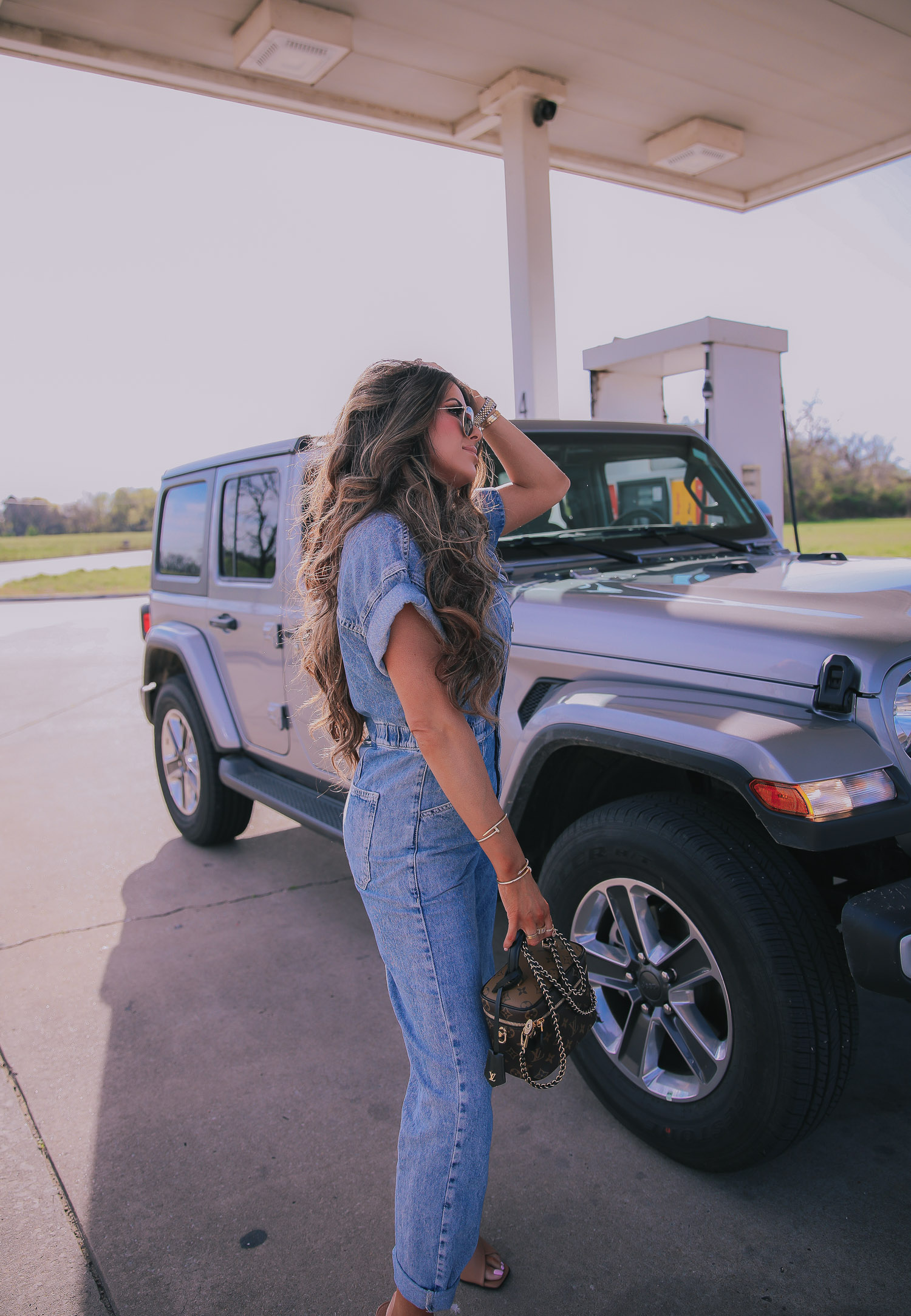 denim jumpsuit, free people denim jumpsuit coverall, emily ann gemma, spring fashion 2020, pinterest spring summer fashion 2020 | Denim Jumpsuit Outfit by popular US fashion blog, The Sweetest Thing: image of Emily Gemma standing in front of a Jeep at a gas station and wearing a Free People Marci Coverall, Cartier rings, Rolex watch, Nordstrom 50mm Retro Inspired Round Metal Sunglasses RAY-BAN, Nordstrom Skyla Slide Sandal TOPSHOP, Ulta KKW BEAUTY  Nude Lip Liner, Nordstrom Hot Lips Lipstick CHARLOTTE TILBURY, and Nordstrom Gloss Luxe Moisturizing Lipgloss TOM FORD.