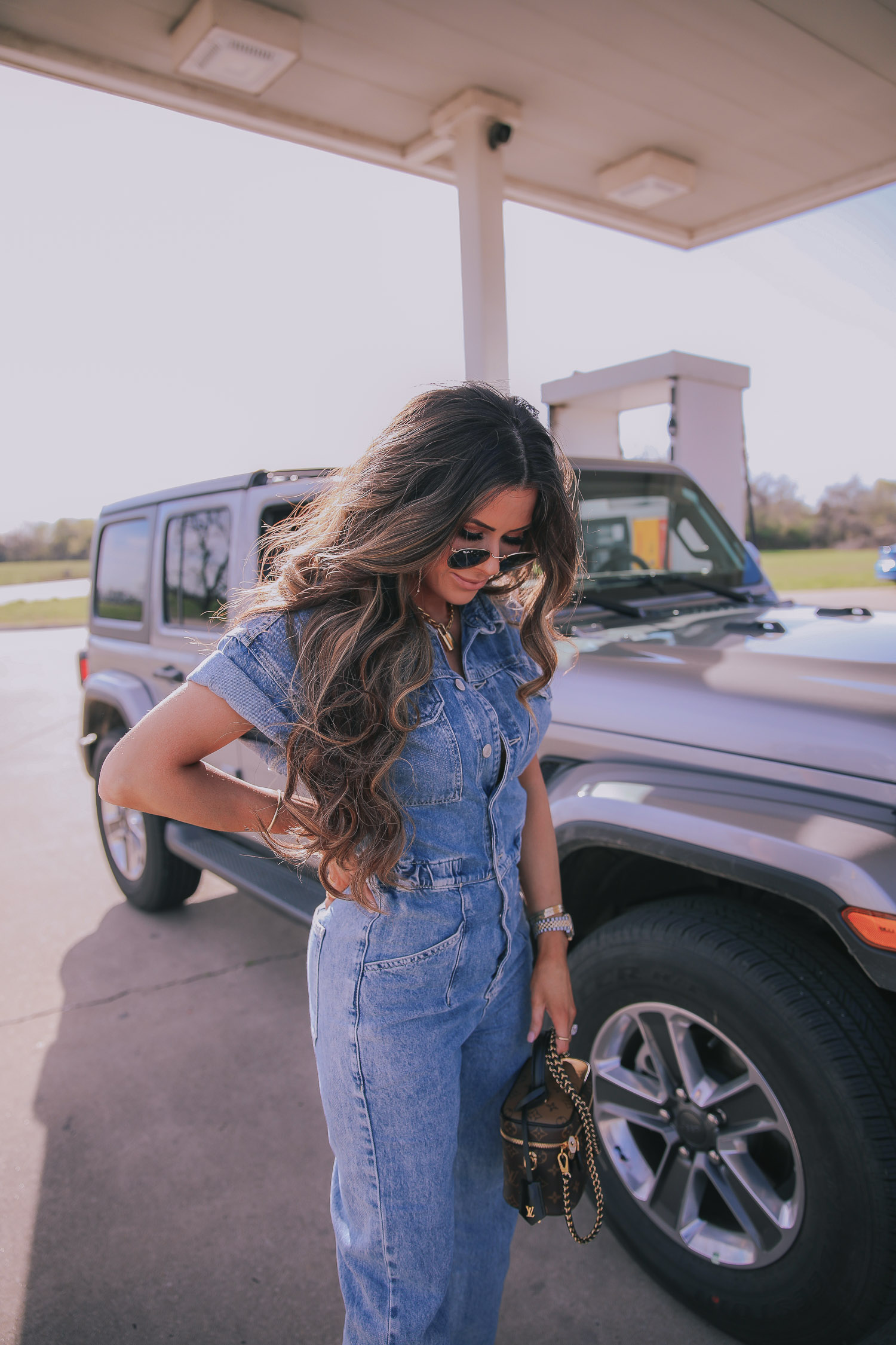 denim jumpsuit, free people denim jumpsuit coverall, emily ann gemma, spring fashion 2020, pinterest spring summer fashion 2020 | Denim Jumpsuit Outfit by popular US fashion blog, The Sweetest Thing: image of Emily Gemma standing in front of a Jeep at a gas station and wearing a Free People Marci Coverall, Cartier rings, Rolex watch, Nordstrom 50mm Retro Inspired Round Metal Sunglasses RAY-BAN, Nordstrom Skyla Slide Sandal TOPSHOP, Ulta KKW BEAUTY  Nude Lip Liner, Nordstrom Hot Lips Lipstick CHARLOTTE TILBURY, and Nordstrom Gloss Luxe Moisturizing Lipgloss TOM FORD.