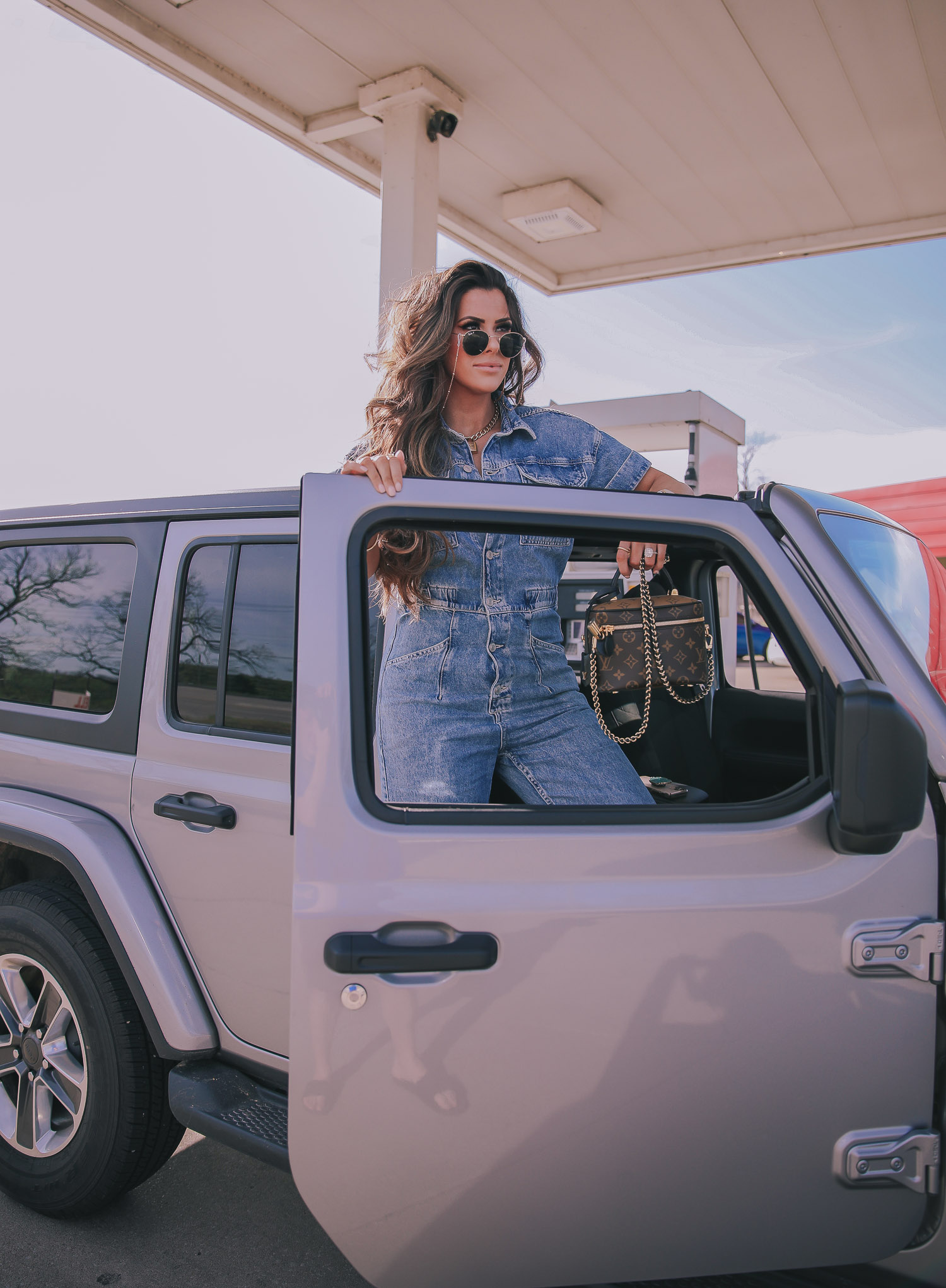 denim jumpsuit, free people denim jumpsuit coverall, emily ann gemma, spring fashion 2020, pinterest spring summer fashion 2020 | Denim Jumpsuit Outfit by popular US fashion blog, The Sweetest Thing: image of Emily Gemma standing in front of a Jeep at a gas station and wearing a Free People Marci Coverall, Cartier rings, Rolex watch, Nordstrom 50mm Retro Inspired Round Metal Sunglasses RAY-BAN, Nordstrom Skyla Slide Sandal TOPSHOP, Ulta KKW BEAUTY  Nude Lip Liner, Nordstrom Hot Lips Lipstick CHARLOTTE TILBURY, and Nordstrom Gloss Luxe Moisturizing Lipgloss TOM FORD.