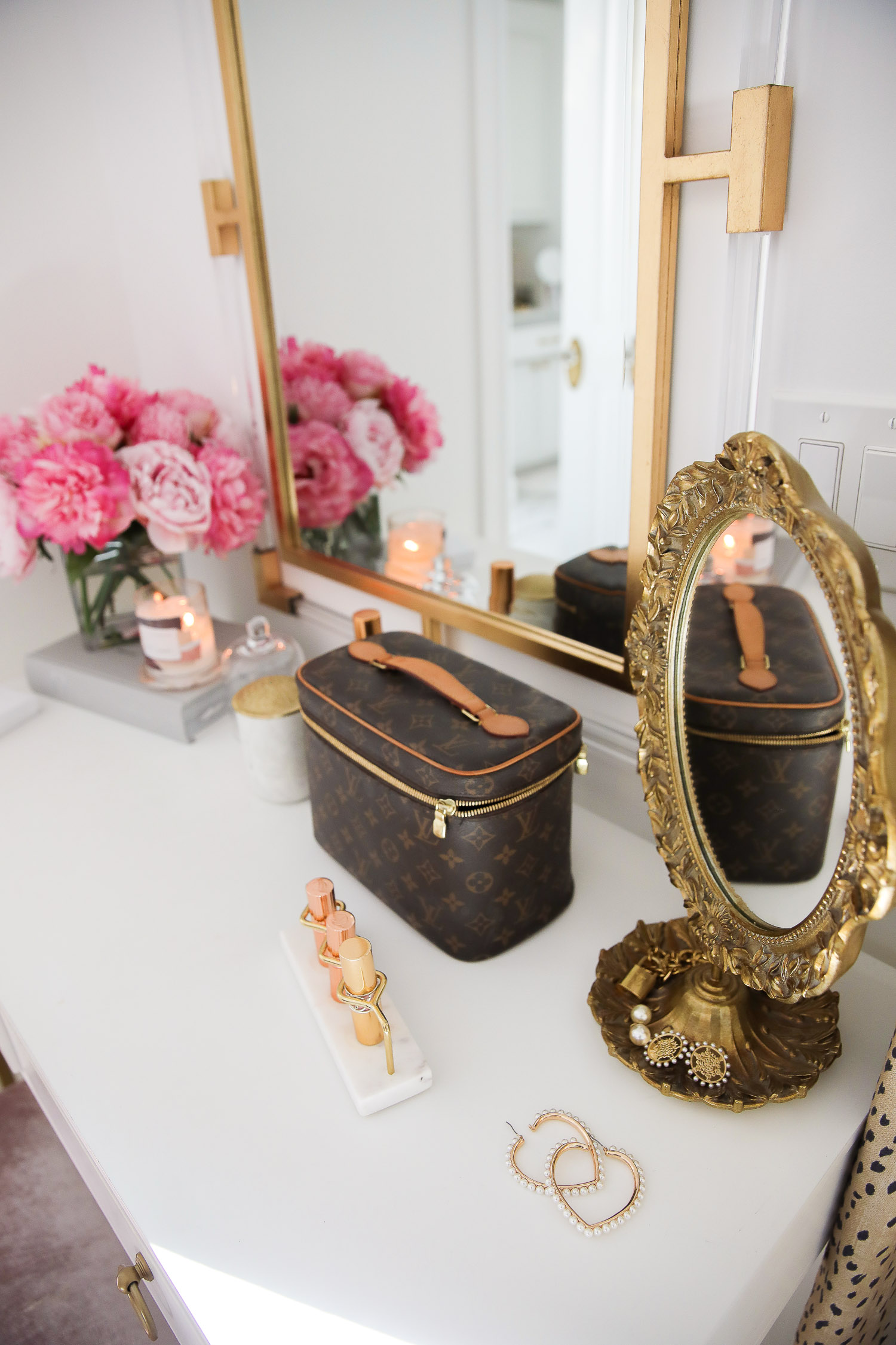  Work From Home Outfits by popular US fashion blog, The Sweetest Thing: image of a vanity with a vase of pink roses, marble and gold lipstick organizer, pearl heart shape earrings, and Louis Vuitton makeup case.