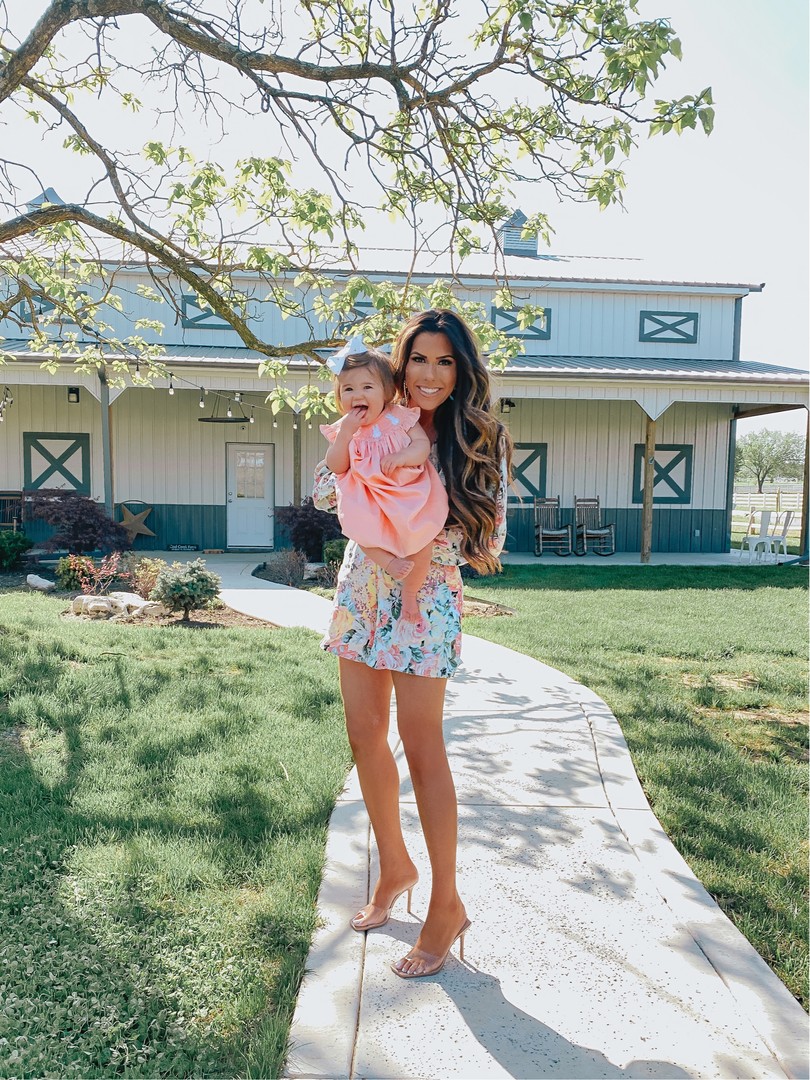 Instagram Recap by popular US life and style blog, The Sweetest Thing: image of Emily Gemma wearing a FAITHFULL THE BRAND Maribelle Romper, Steve Madden clear heels, Lisi Lerch ASCHER earrings and holding her daughter Sophie who is wearing a Smocked Auctions dress.