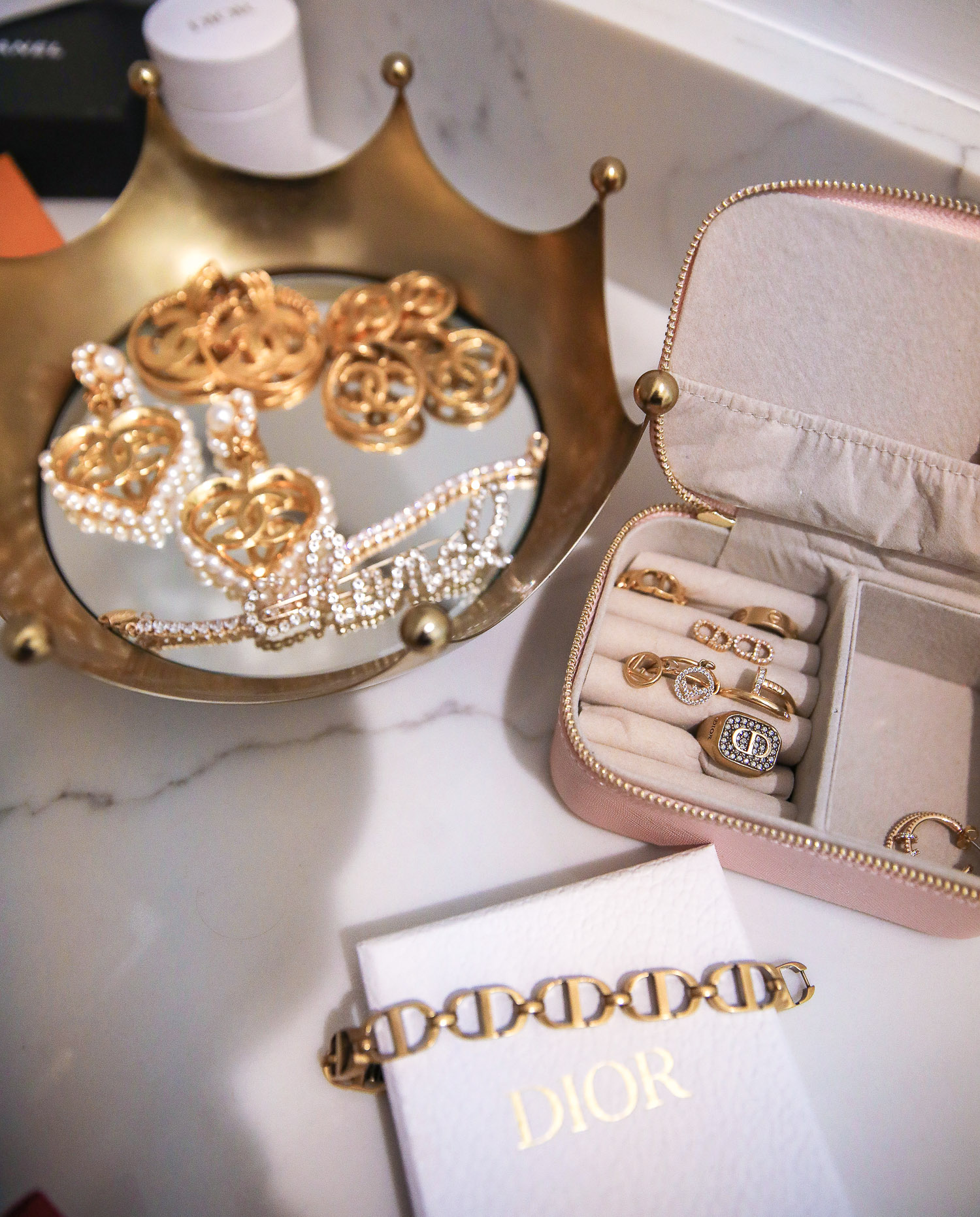 jewelry storage and organization, master bedroom decoration and design, designer jewelry storage | Nighttime Routine by popular US beauty blog, The Sweetest Thing: image of Chanel jewelry in a crown jewelry dish, a Dior bracelet, and Dior and Fendi rings in a pink jewelry case. 