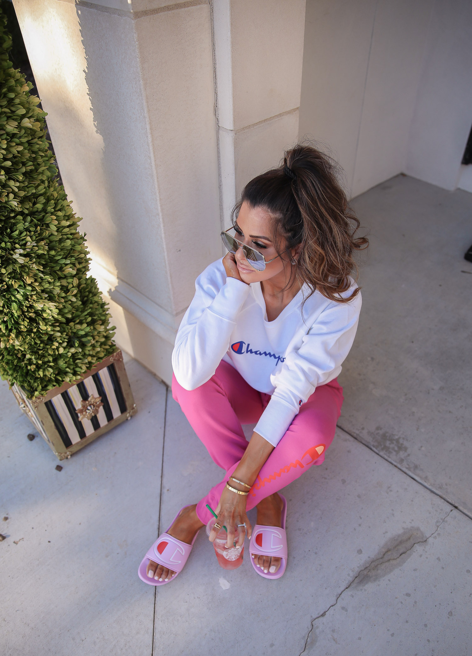 champion sweatshirt, pink champion slides, walmart fashion 2020, emily gemma, walmart champion outfit | Champion Outfit by popular US fashion blog, The Sweetest Thing: image of Emily Gemma sitting outside and wearing a Walmart Champion Women's Powerblend Fleece Boyfriend Crew Neck Sweatshirt, Walmart Champion Women's Powerblend Fleece Joggers-Graphic, Walmart Champion Women's IPO Slide, Walmart Revlon Super Lustrous Lipstick, Walmart NYX Professional Makeup Retractable Lip Liner, and Walmart e.l.f. Lip Plumping Gloss.