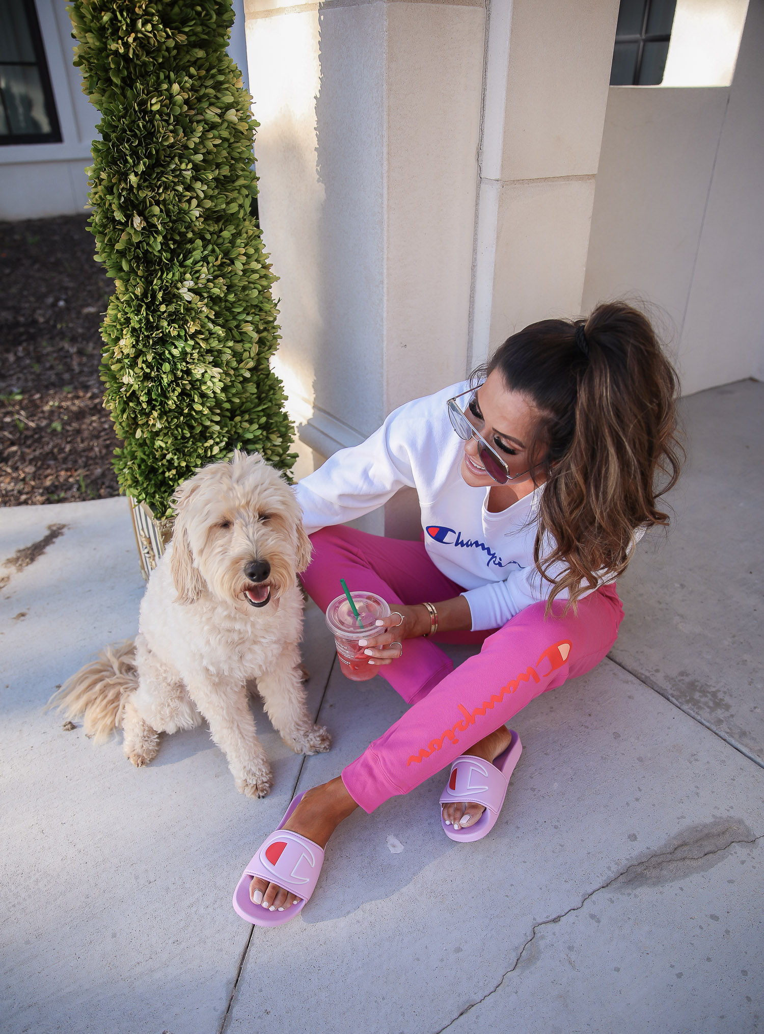 champion sweatshirt, pink champion slides, walmart fashion 2020, emily gemma, walmart champion outfit | Champion Outfit by popular US fashion blog, The Sweetest Thing: image of Emily Gemma sitting outside and wearing a Walmart Champion Women's Powerblend Fleece Boyfriend Crew Neck Sweatshirt, Walmart Champion Women's Powerblend Fleece Joggers-Graphic, Walmart Champion Women's IPO Slide, Walmart Revlon Super Lustrous Lipstick, Walmart NYX Professional Makeup Retractable Lip Liner, and Walmart e.l.f. Lip Plumping Gloss.