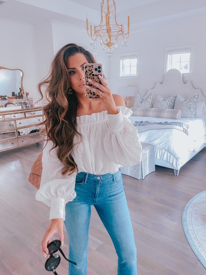  Instagram Recap by popular US life an style blog, The Sweetest Thing: image of Emily Gemma standing in her master bedroom in front of a The Chic Nest bed with Little Design Co. pillows and wearing a pair of Mother jeans, H&M off the shoulder white top, and holding a pair of Celine sunglasses. 