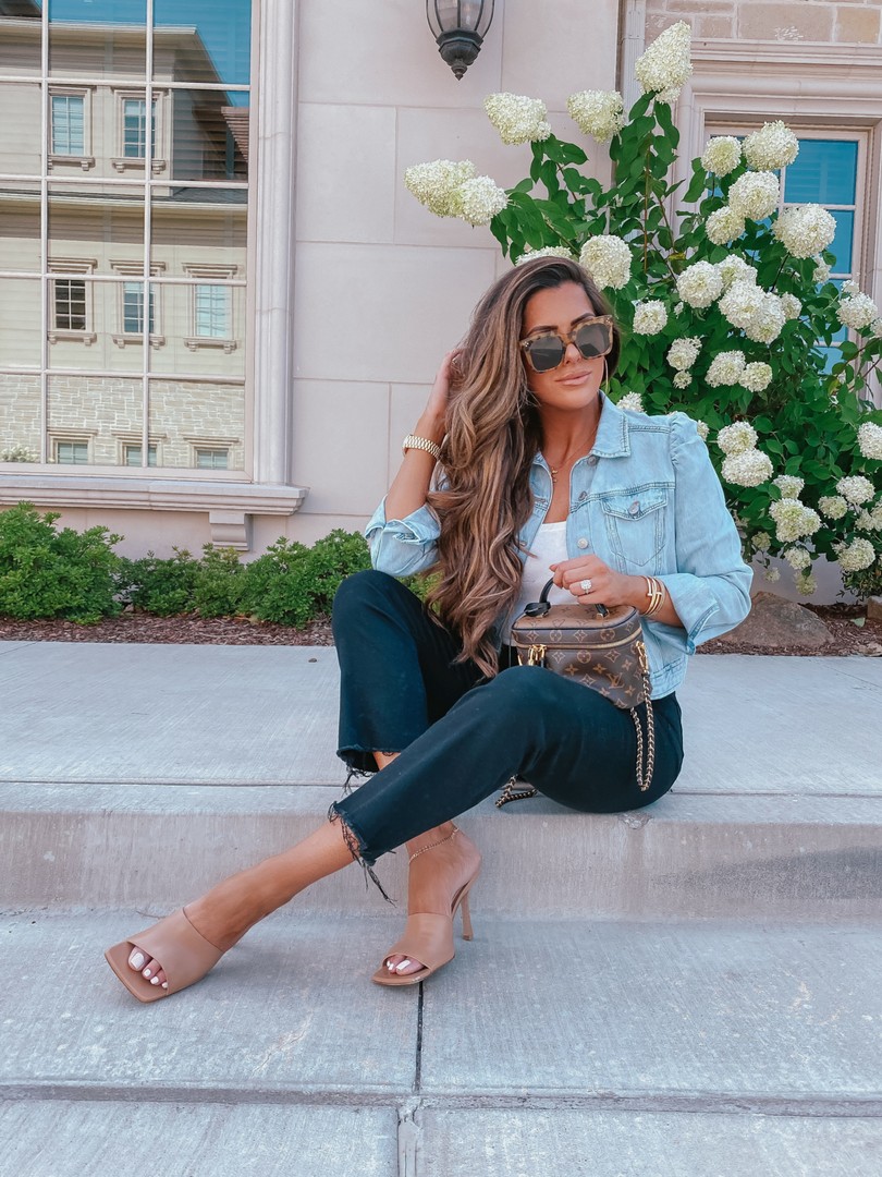  Instagram Recap by popular US life an style blog, The Sweetest Thing: image of Emily Gemma sitting outside and wearing an Express puff sleeve denim jacket, Express sweater cami, Express high waisted black denim, Express earrings, Express anklet, Bottega Veneta heels, Cartier bracelets, Chloe necklace and holding a Louis Vuitton bag. 