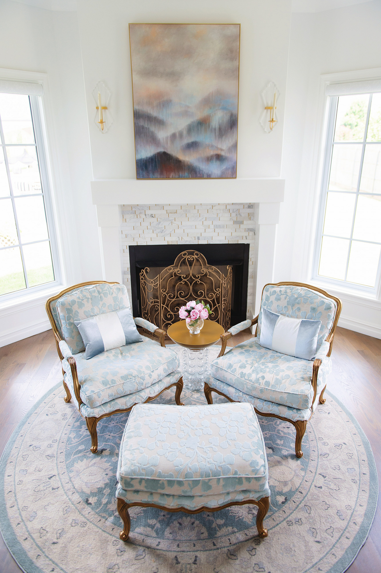 Blog Design by popular US lifestyle blog, The Sweetest Thing: image of a sitting nook with a blue and white print round rug, matching blue and cream arm chairs, and a fireplace with a gold grate. 