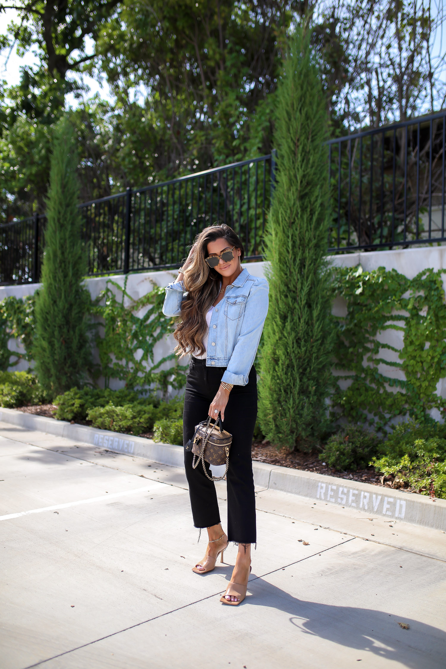  Instagram Recap by popular US life an style blog, The Sweetest Thing: image of Emily Gemma sitting outside and wearing an Express puff sleeve denim jacket, Express sweater cami, Express high waisted black denim, Express earrings, Express anklet, Bottega Veneta heels, Cartier bracelets, Chloe necklace and holding a Louis Vuitton bag. 