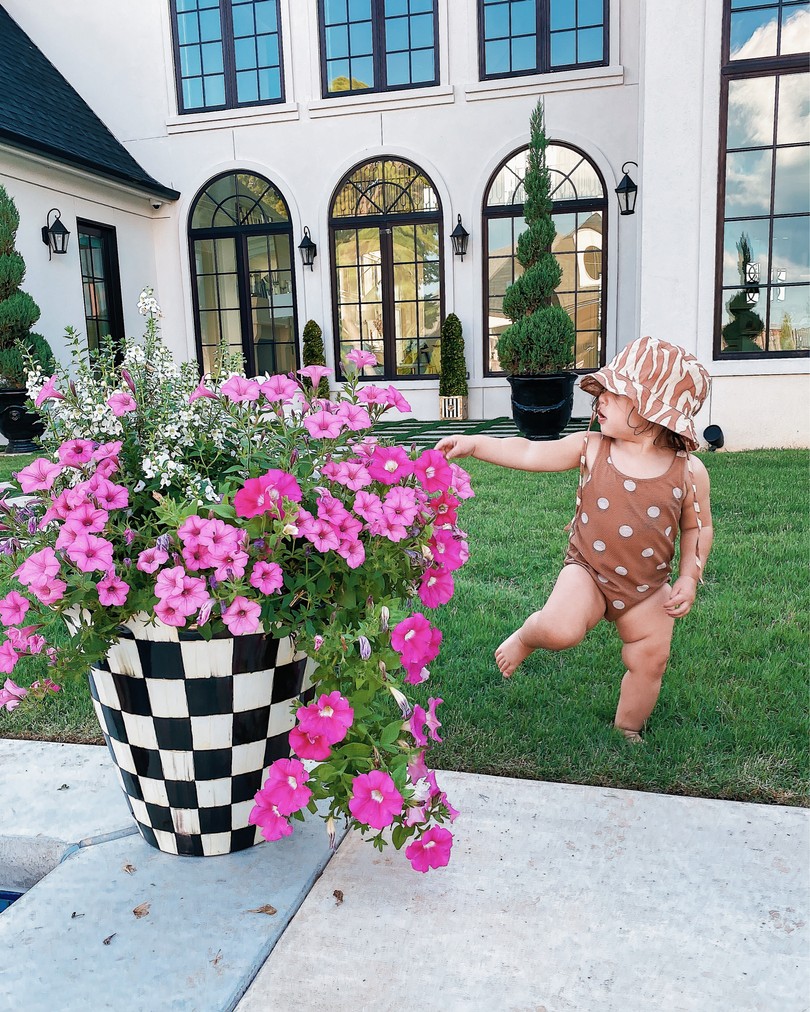backyard decor, Mackenzie-Childs, Baby swimsuits, Emily Ann Gemma |Instagram Recap by popular US life and style blog, The Sweetest Thing: image of a baby girl standing next to a Mackenzie-Childs flower pot and wearing a H&M hat and H&m brown and white polka dot swimsuit. 