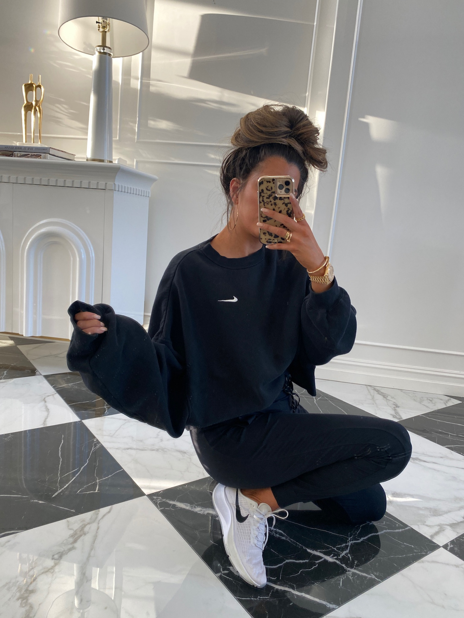 Nordstrom Anniversary Sale 2021 favorites by top US fashion blogger, The Sweetest Thing. | Nordstrom Anniversary Sale by popular US fashion blog, The Sweetest Thing: image of Emily Gemma wearing a black Nike sweatshirt, black joggers, and grey Nike sneakers. 