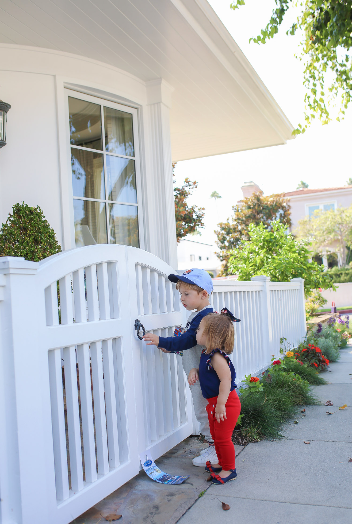 Janie and Jack by popular US fashion Blog, The Sweetest Thing: image of two kids walking outside on a sidewalk in Newport Beach, CA and wearing a Janie and Jack TIGER PATCH CAP, Janie and Jack RAGLAN TIGER SWEATSHIRT, Janie and Jack STRIPE TRIM JOGGER, Janie and Jack PLEATED SLEEVE TOP, Janie and Jack BUTTON PONTE PANT, Janie and Jack BOW ANKLE STRAP FLAT, FLORAL BOW BARRETTE, and Janie and Jack BOUCLÉ PURSE.