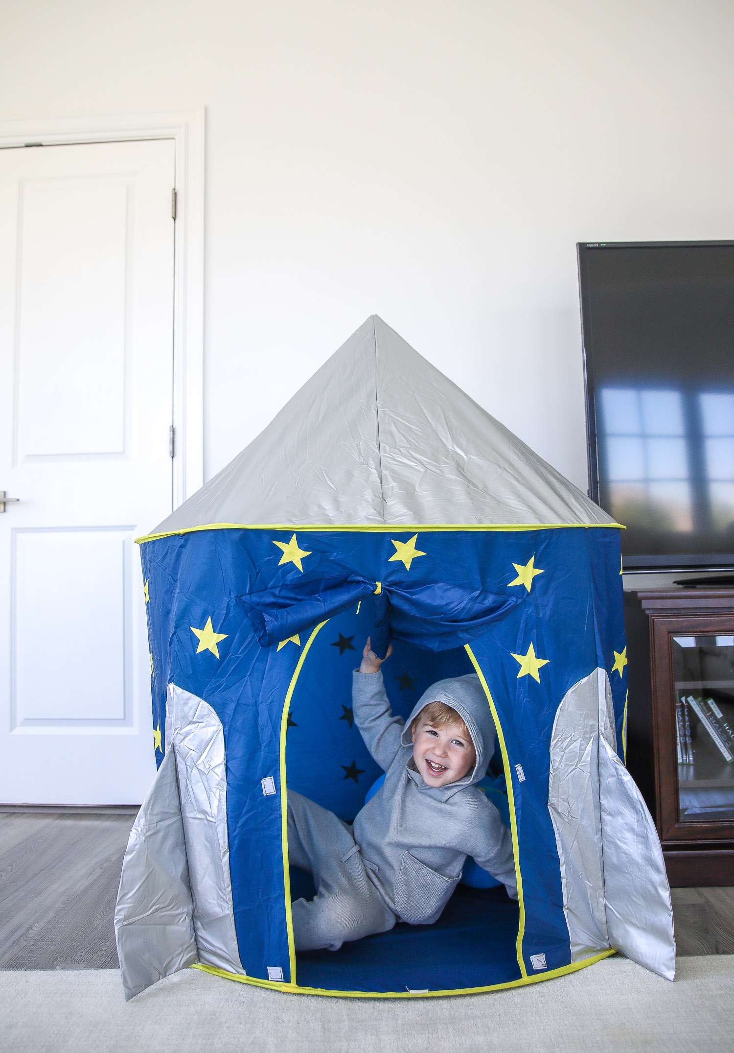 walmart kids home organization must haves, playroom organization ideas, emily gemma, the sweetest thing blog | Playroom Organization by popular US life and style blog, The Sweetest Thing: image of a little boy sitting in a rocket ship pop up tent. 