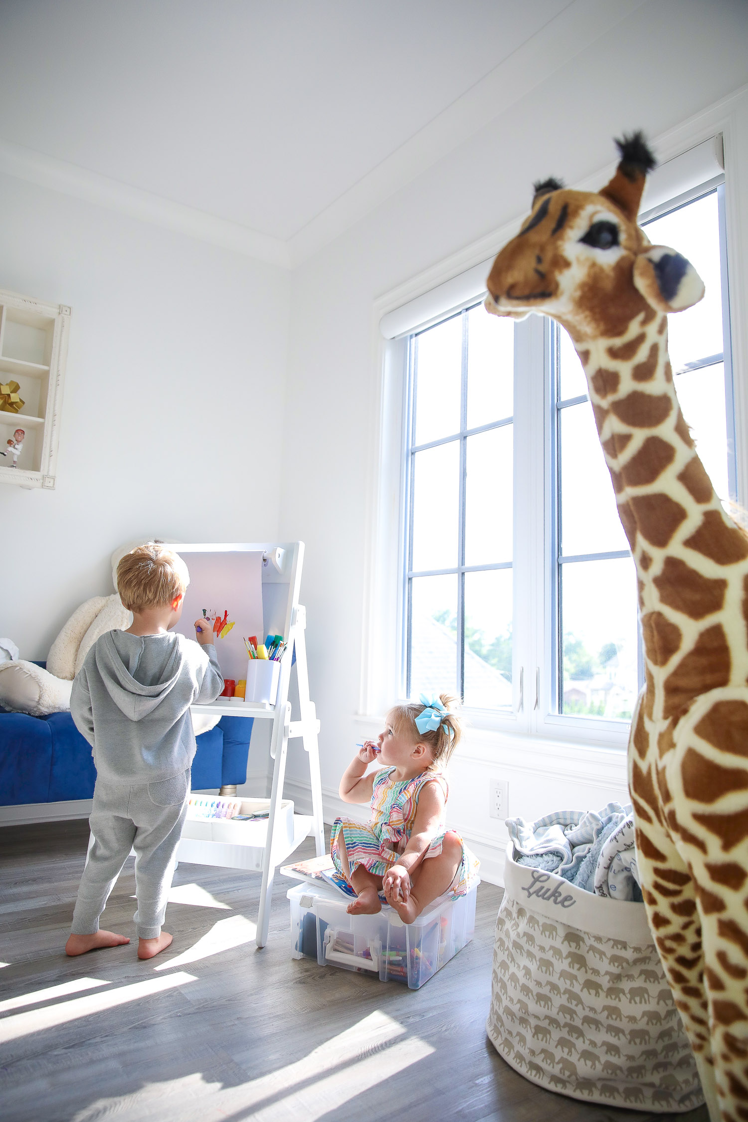 walmart kids home organization must haves, playroom organization ideas, emily gemma, the sweetest thing blog |Instagram Recap by popular US lifestyle blog, The Sweetest Thing: image of a young boy and girl in a play room with a Delta Children whiteboard, Humble Crew storage, Melissa and Doug giraffe, and ArtBin art container. 