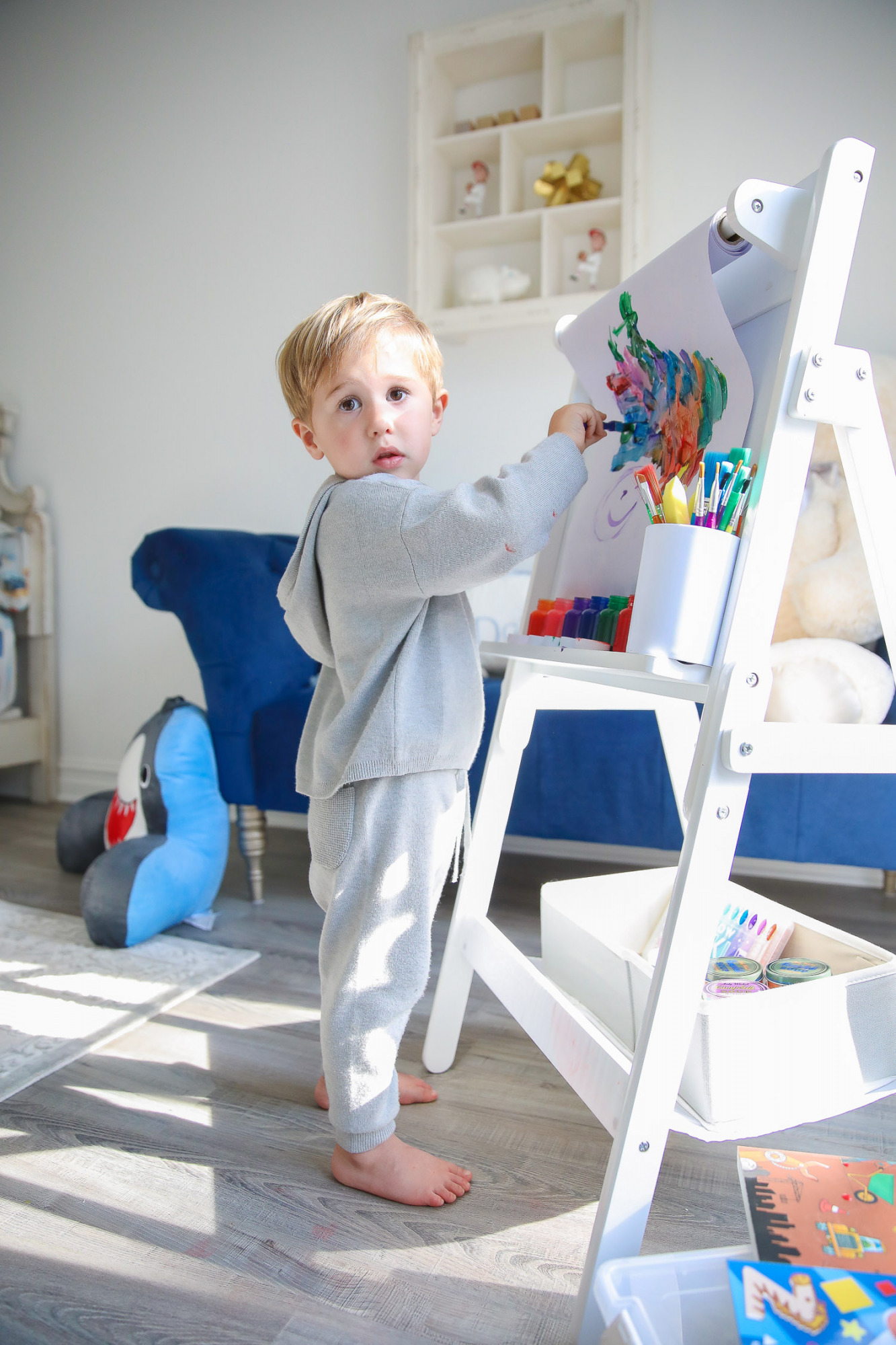 walmart kids home organization must haves, playroom organization ideas, emily gemma, the sweetest thing blog | Playroom Organization by popular US life and style blog, The Sweetest Thing: image of a little boy painting on a Walmart Delta Children Classic Kids Whiteboard/Dry Erase Easel with Paper Roll and Storage with Walmart Go Create Assorted Paint Brushes and Walmart Cra-Z-Art Washable Kids Paint.