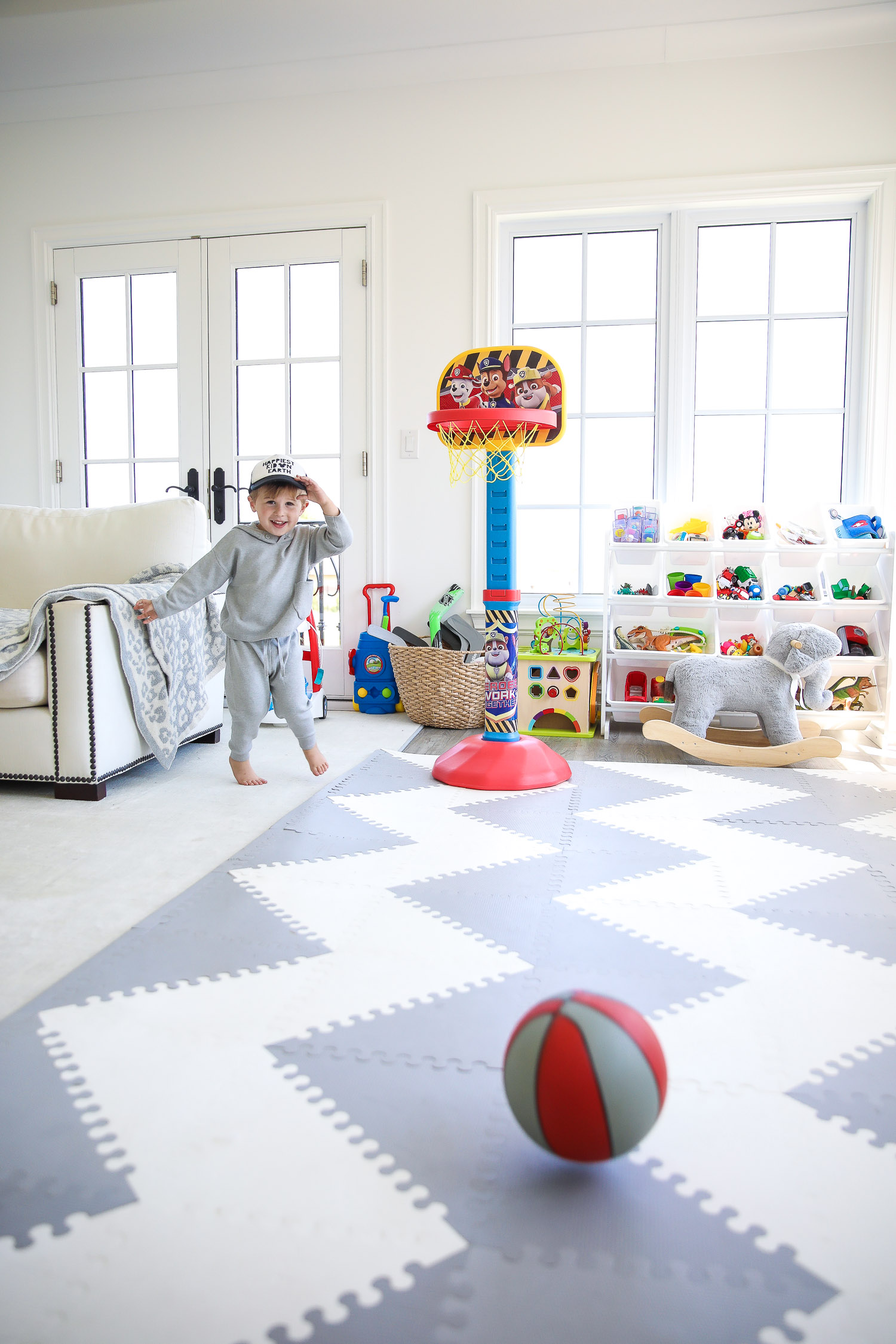 walmart kids home organization must haves, playroom organization ideas, emily gemma, the sweetest thing blog | Playroom Organization by popular US life and style blog, The Sweetest Thing: image of a playroom set up with a Walmart Humble Crew Super-Sized Toy Organizer with 16 Plastic Bins, foam flooring, basketball hoop, and rocking elephant. 