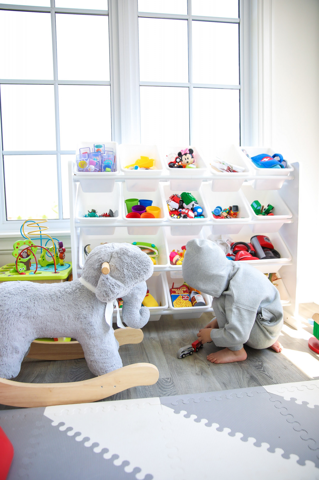 walmart kids home organization must haves, playroom organization ideas, emily gemma, the sweetest thing blog | Playroom Organization by popular US life and style blog, The Sweetest Thing: image of a playroom set up with a Walmart Humble Crew Super-Sized Toy Organizer with 16 Plastic Bins, foam flooring, basketball hoop, and rocking elephant. 