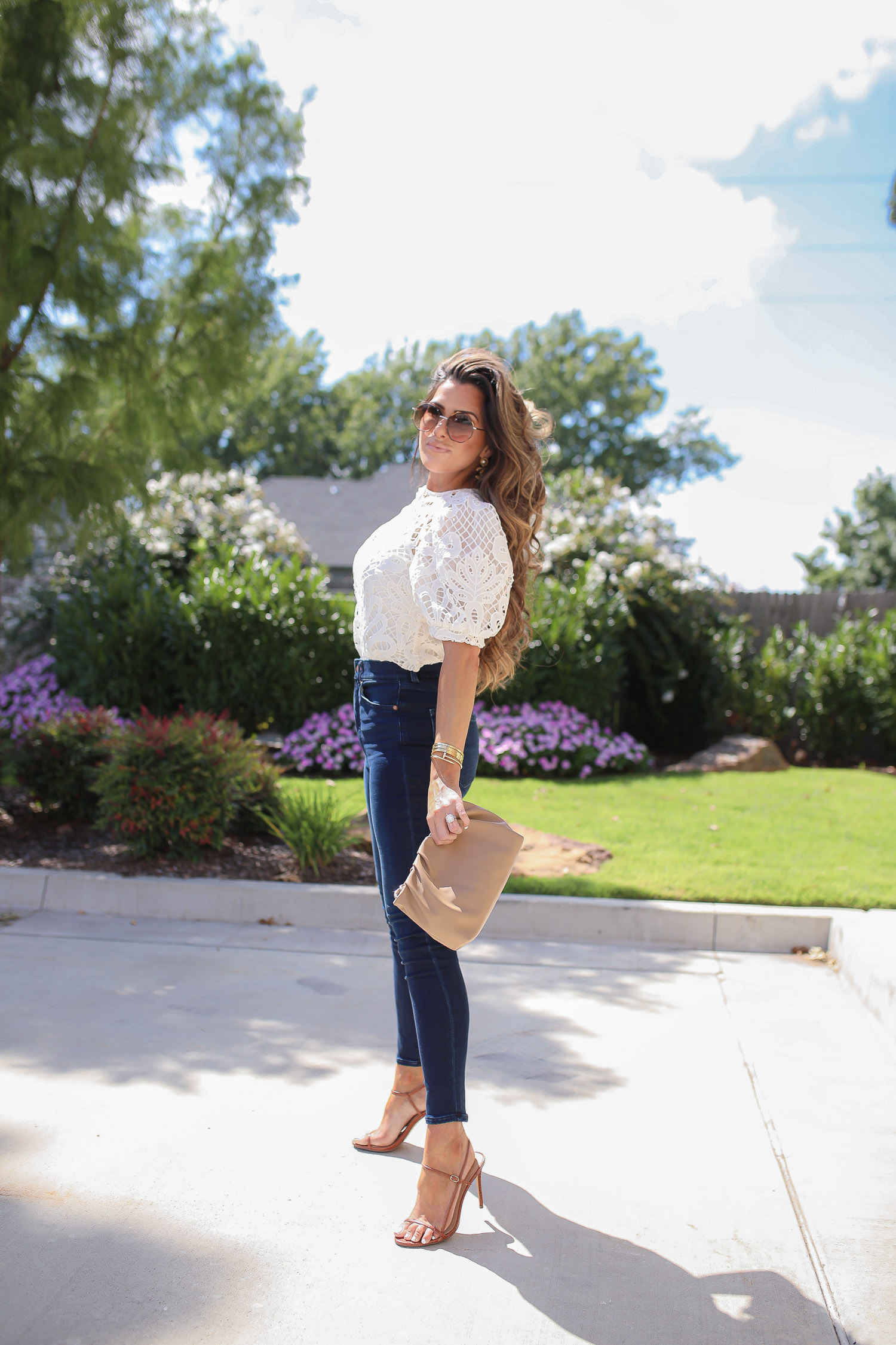 express fall 2020, express fall fashion trends 2020 pinterest, emily ann gemma, zimmermann dupe lookalike top, chloe dupe sunglasses | Fall Clothing by popular US fashion blog, The Sweetest Thing: image of Emily Gemma sitting down outside and wearing a Express Lace Puff Sleeve Top, Express High Waisted Luxe Comfort Knit Faded Skinny Jeans, Express Octagon Cut-Out Sunglasses, Express Thin Strap Textured Heels, Chanel earrings, and Cartier bracelets.