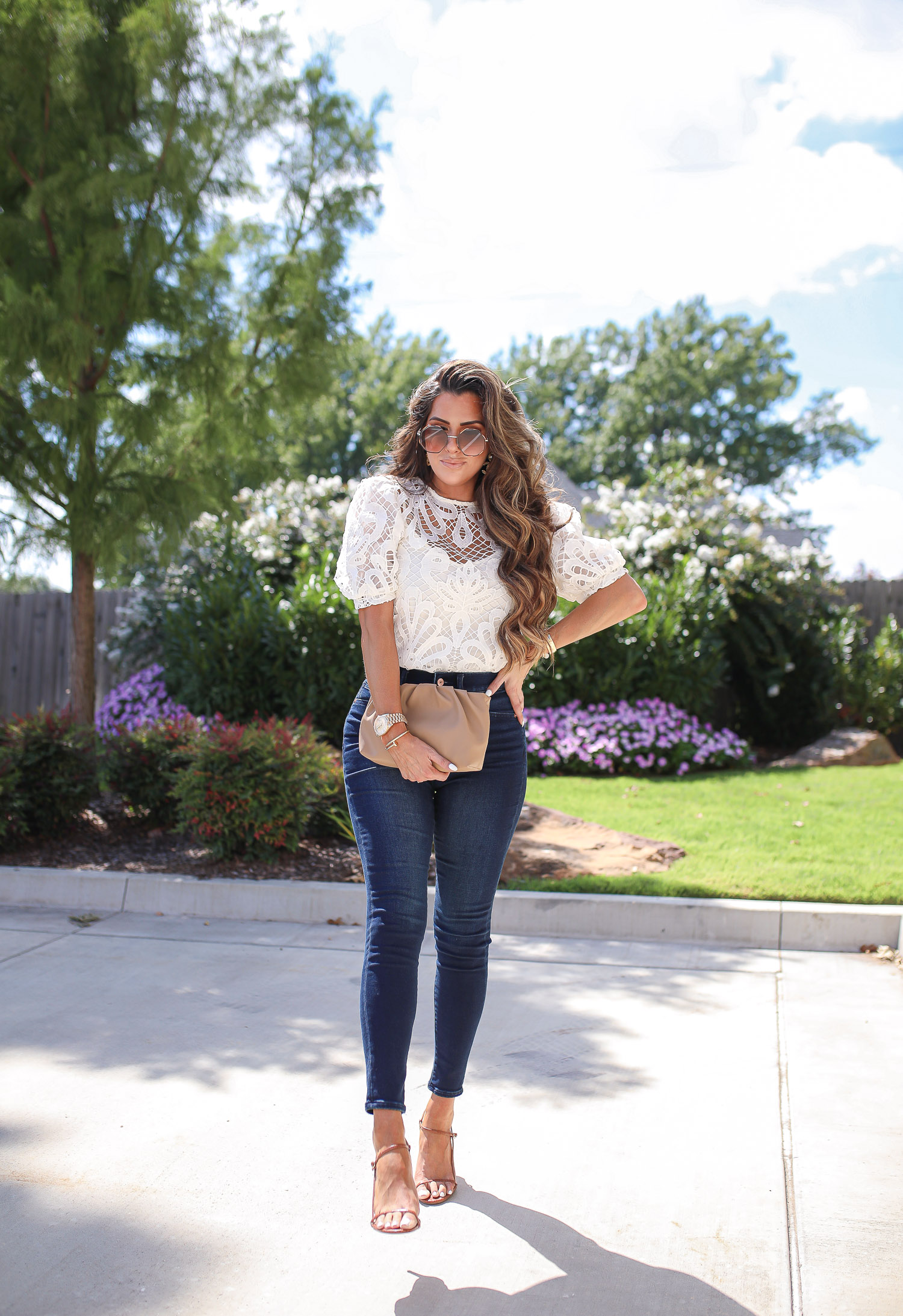 express fall 2020, express fall fashion trends 2020 pinterest, emily ann gemma, zimmermann dupe lookalike top, chloe dupe sunglasses | Fall Clothing by popular US fashion blog, The Sweetest Thing: image of Emily Gemma sitting down outside and wearing a Express Lace Puff Sleeve Top, Express High Waisted Luxe Comfort Knit Faded Skinny Jeans, Express Octagon Cut-Out Sunglasses, Express Thin Strap Textured Heels, Chanel earrings, and Cartier bracelets. 