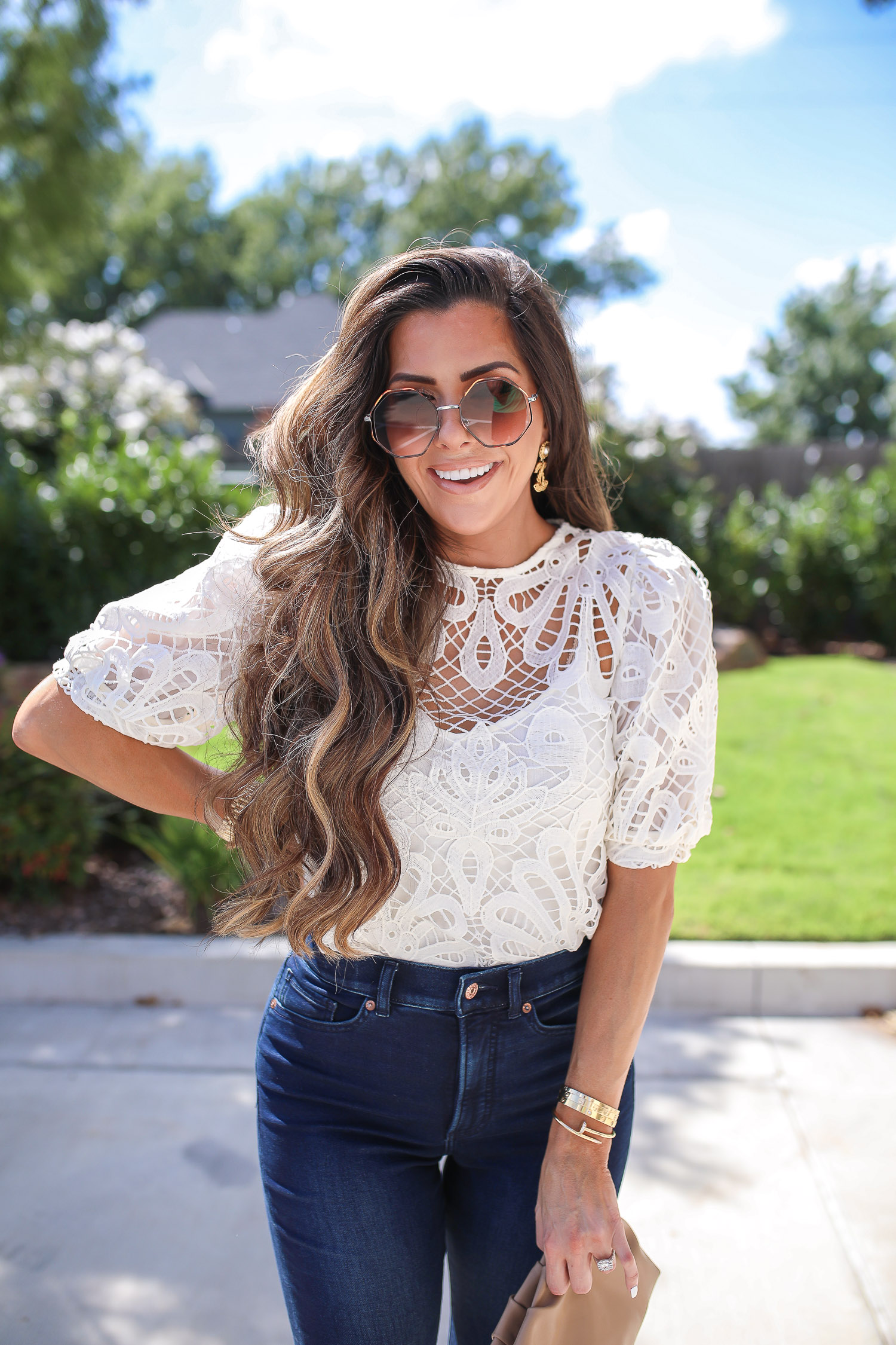 express fall 2020, express fall fashion trends 2020 pinterest, emily ann gemma, zimmermann dupe lookalike top, chloe dupe sunglasses | Fall Clothing by popular US fashion blog, The Sweetest Thing: image of Emily Gemma sitting down outside and wearing a Express Lace Puff Sleeve Top, Express High Waisted Luxe Comfort Knit Faded Skinny Jeans, Express Octagon Cut-Out Sunglasses, Express Thin Strap Textured Heels, Chanel earrings, and Cartier bracelets.