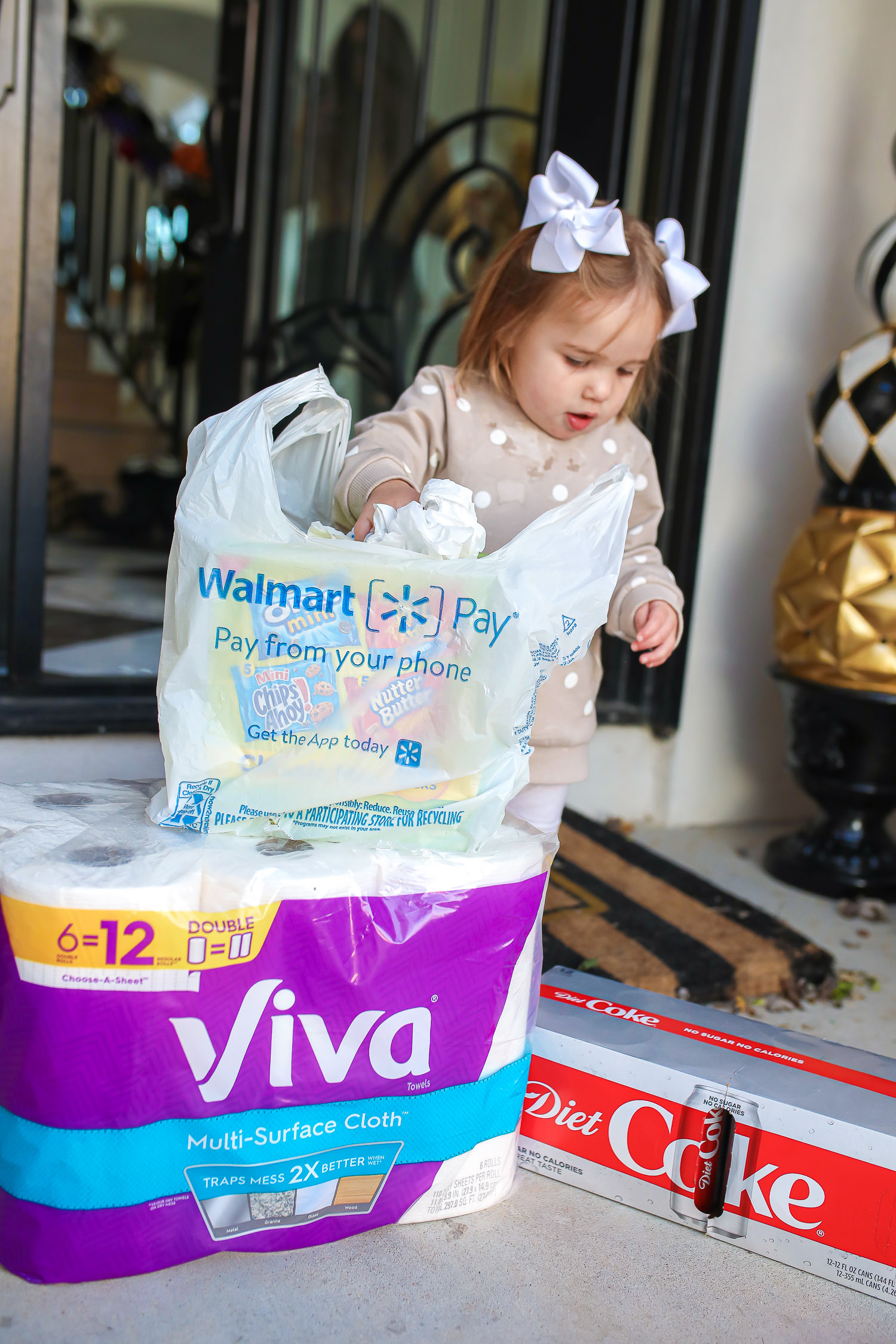 walmart online pickup and delivery review, easiest way to order groceries online, walmart online grocery order, emily ann gemma | Walmart Grocery Pickup Faq by top US lifestyle blog, The Sweetest Thing: image of Emily Gemma's daughter Sophie standing on their front porch next to a package of VIva toilet paper and a case of Diet Coke. 