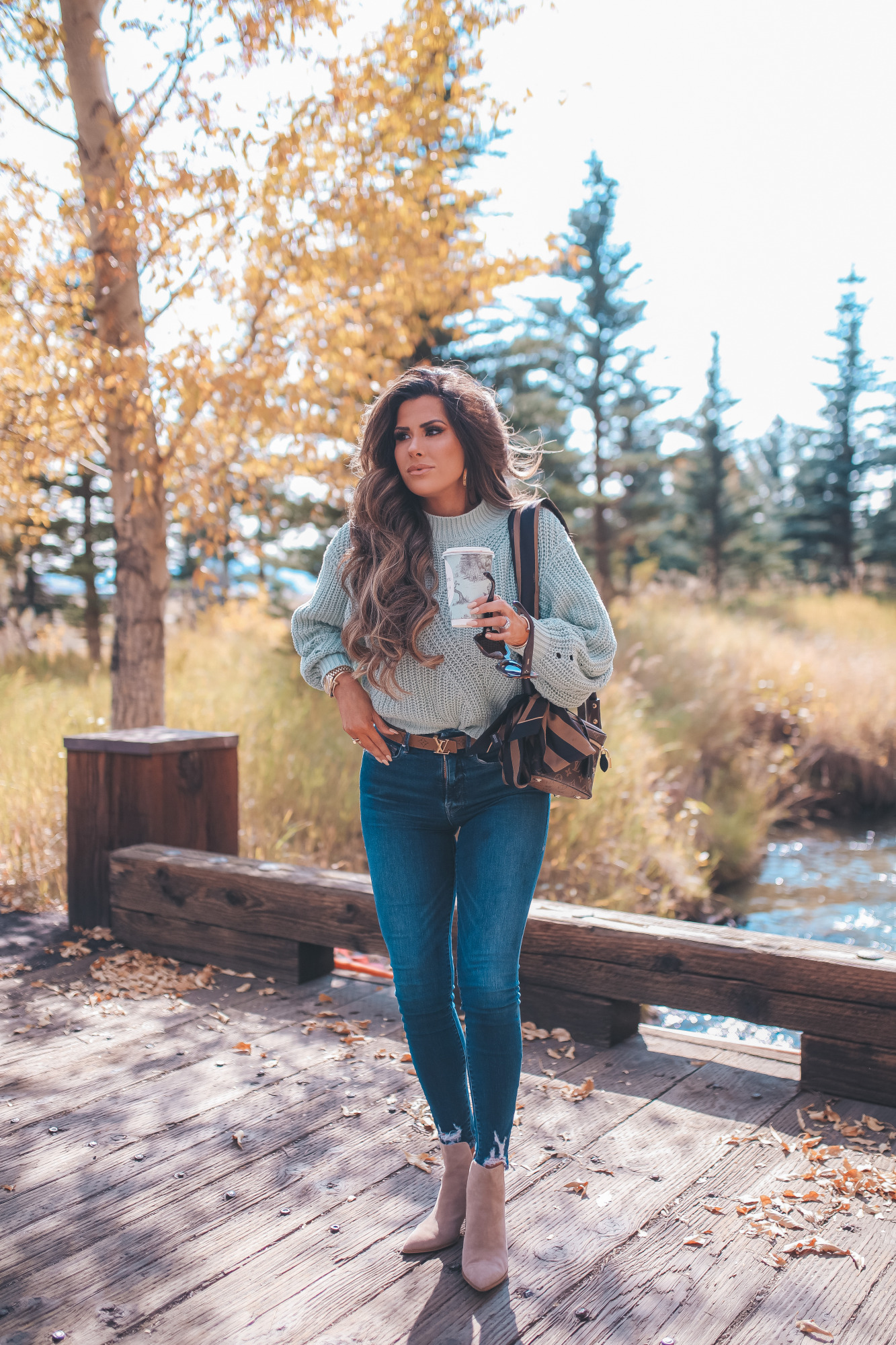 Fall Clothing by popular US fashion blog, The Sweetest Thing: image of Emily Gemma outside at Jackson Hole and wearing a Nordstrom BP.Traveling Stitch Sweater, Nordstrom Good American Good Waist Distressed High Waist Ankle Skinny Jeans, Nordstrom Steve Madden Kaylah Pointed Toe Bootie, and sitting next to a pair of Nordstrom Celine 54mm Cat Eye Sunglasses.